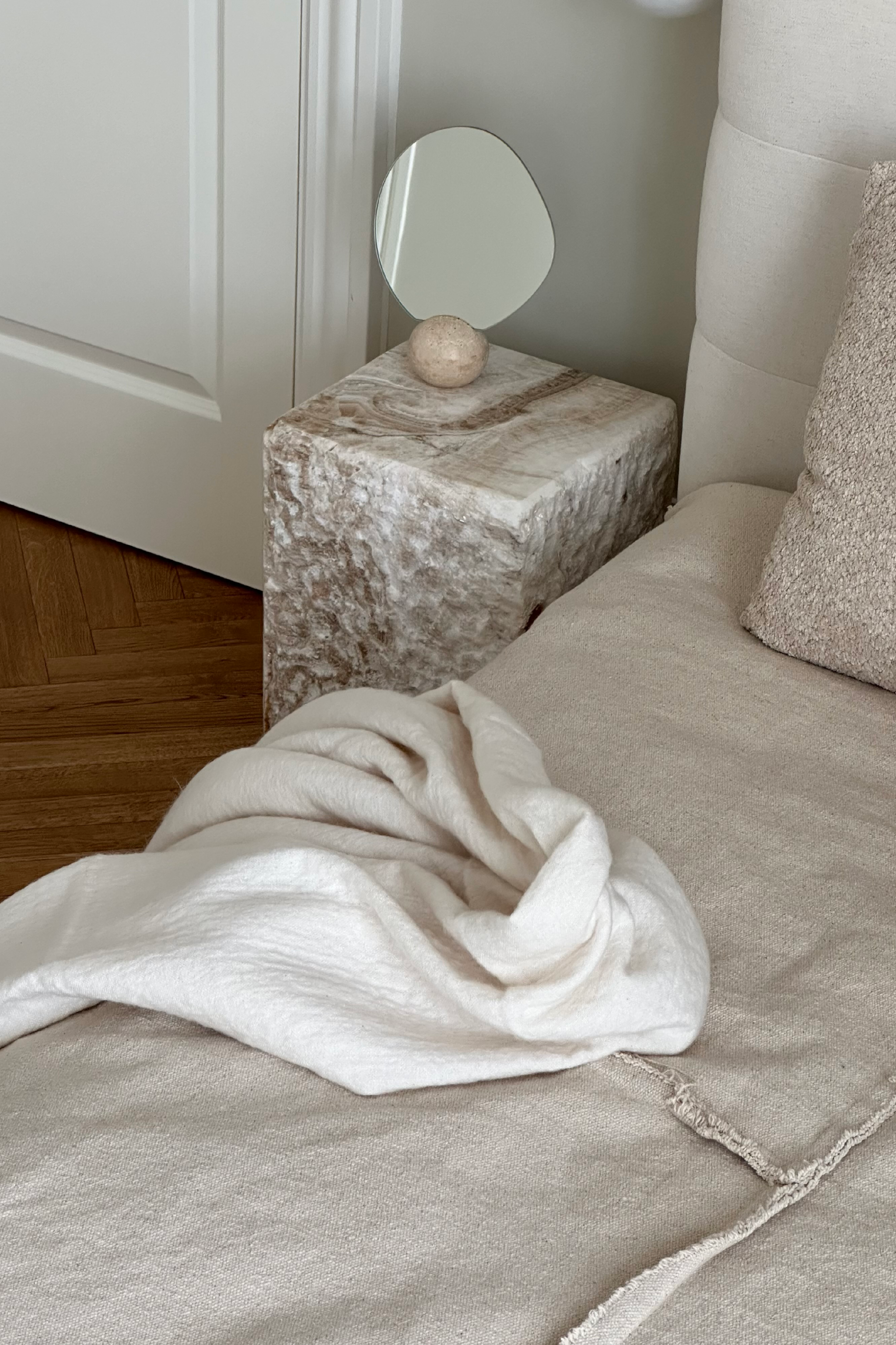 Et soveværelse med et sidebord, hvorpå Asta bordspejlet er sat.