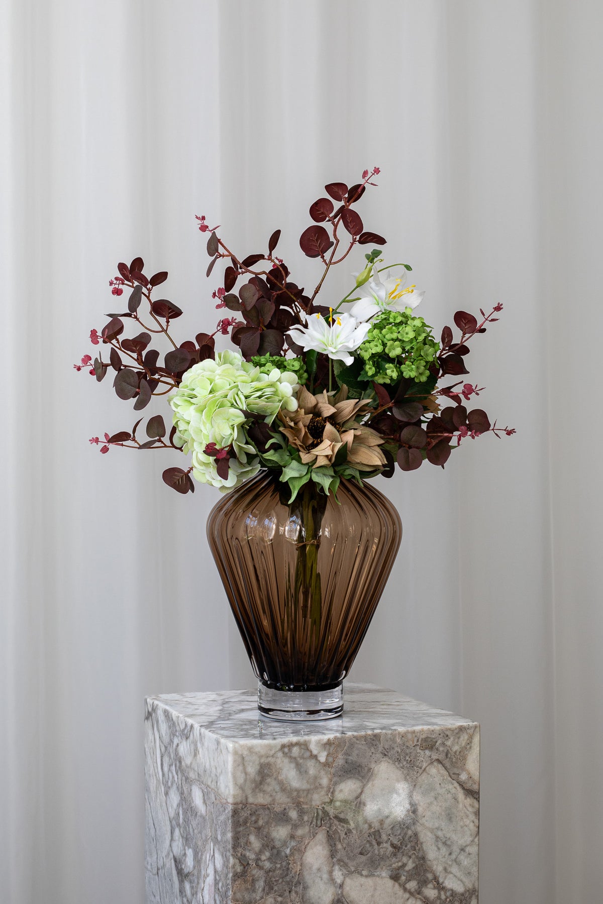 En buket til en du holder af, bare fordi. Den kunstige buket bestyr af en solsikke, hortensia og andre stilke, der skaber den perfekte og naturtro buket.