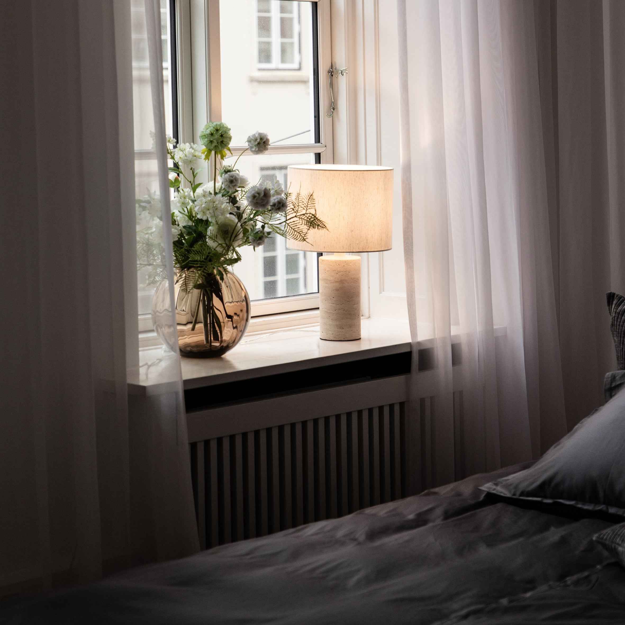 Julia bordlampen der er fremstillet i travertin, placeret i soveværelset.