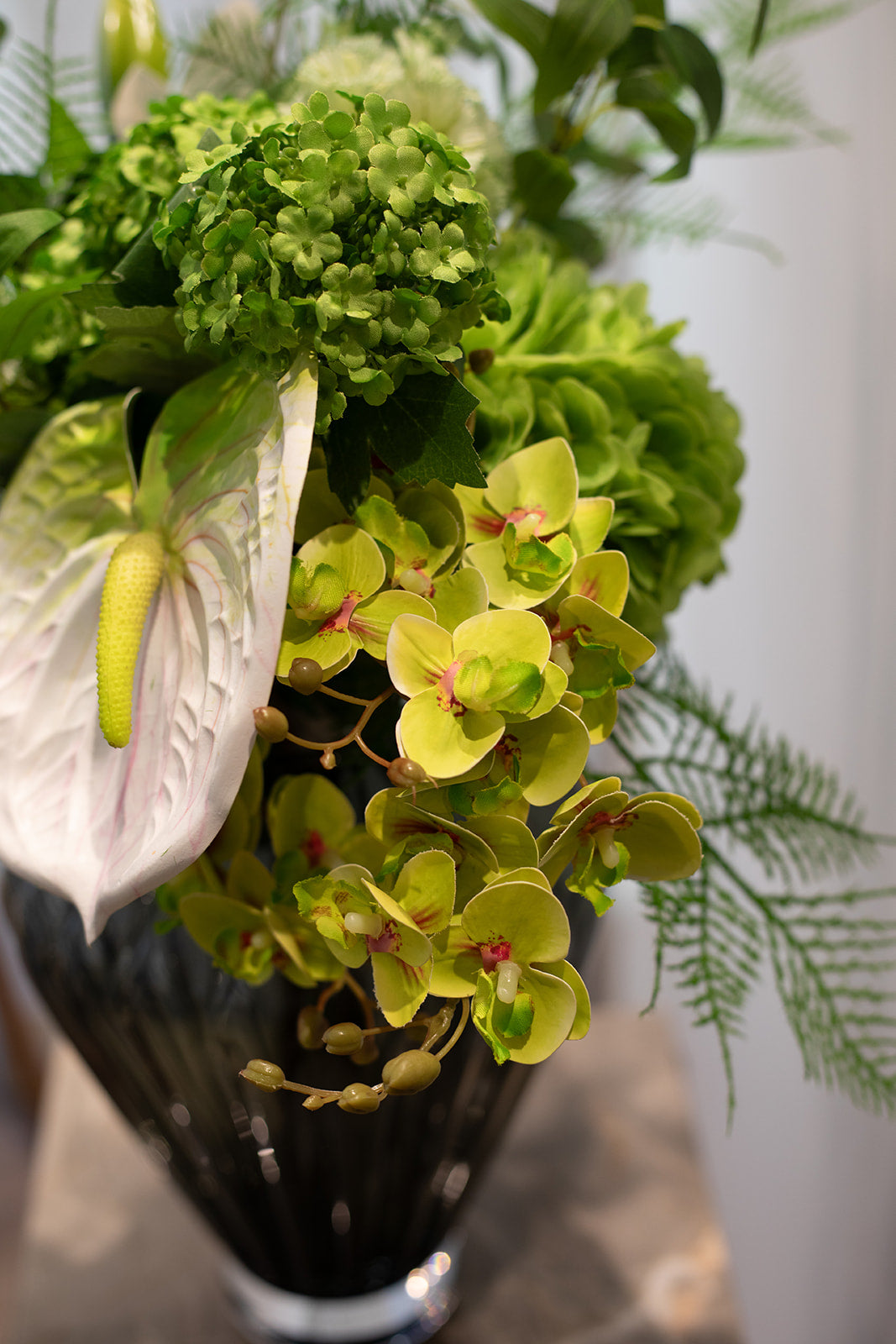 Nærbillede af kunstig buket i grønne og hvide nuancer.