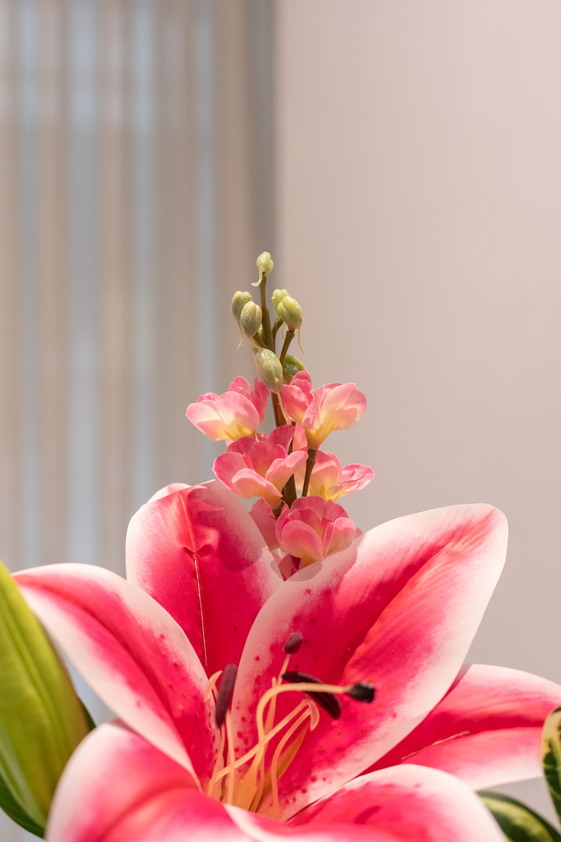 Nærbillede af buket af kunstige blomster i lyserøde og grønne nuancer.