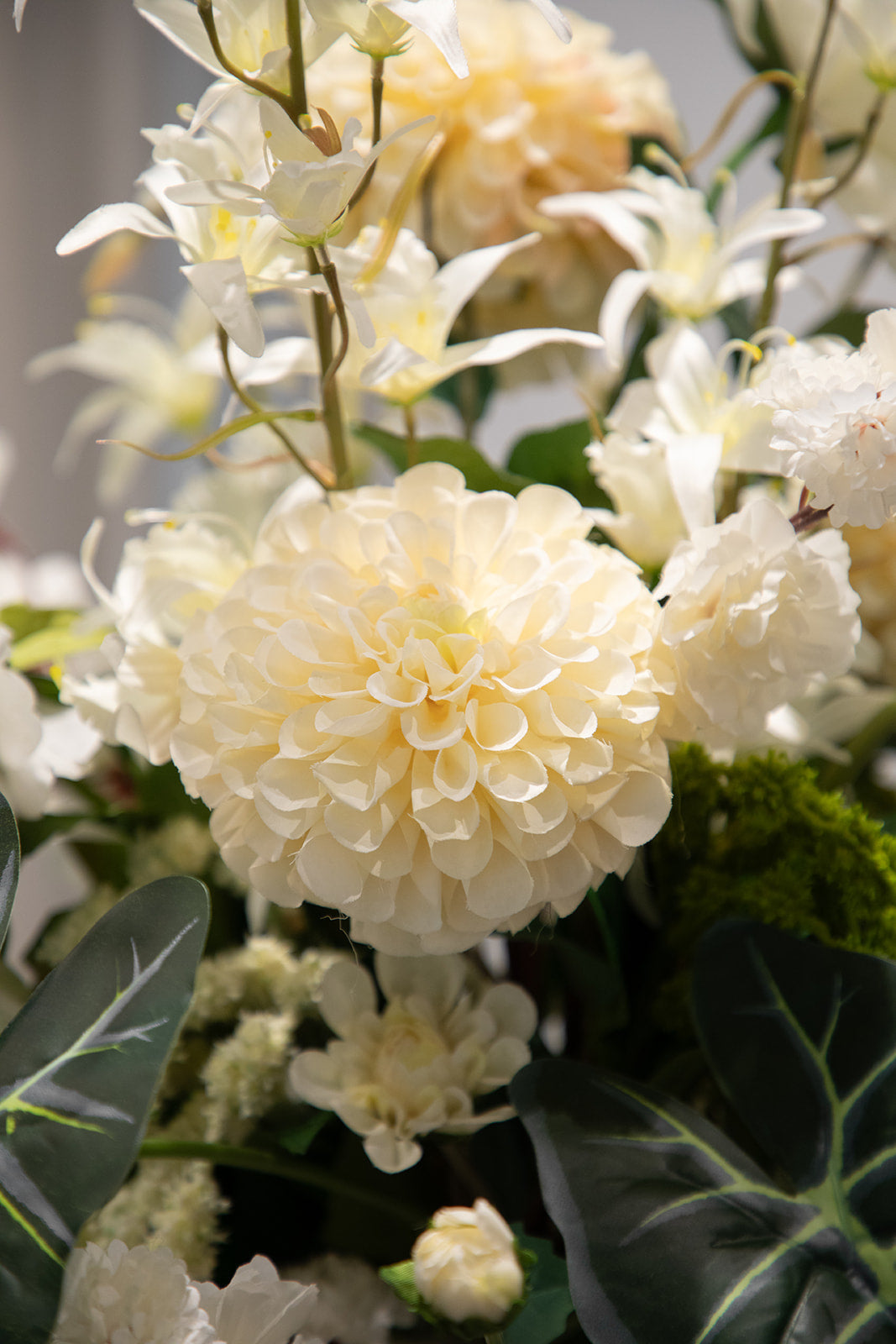Nærbillede af buket af kunstige blomster i grønne og hvide nuancer.