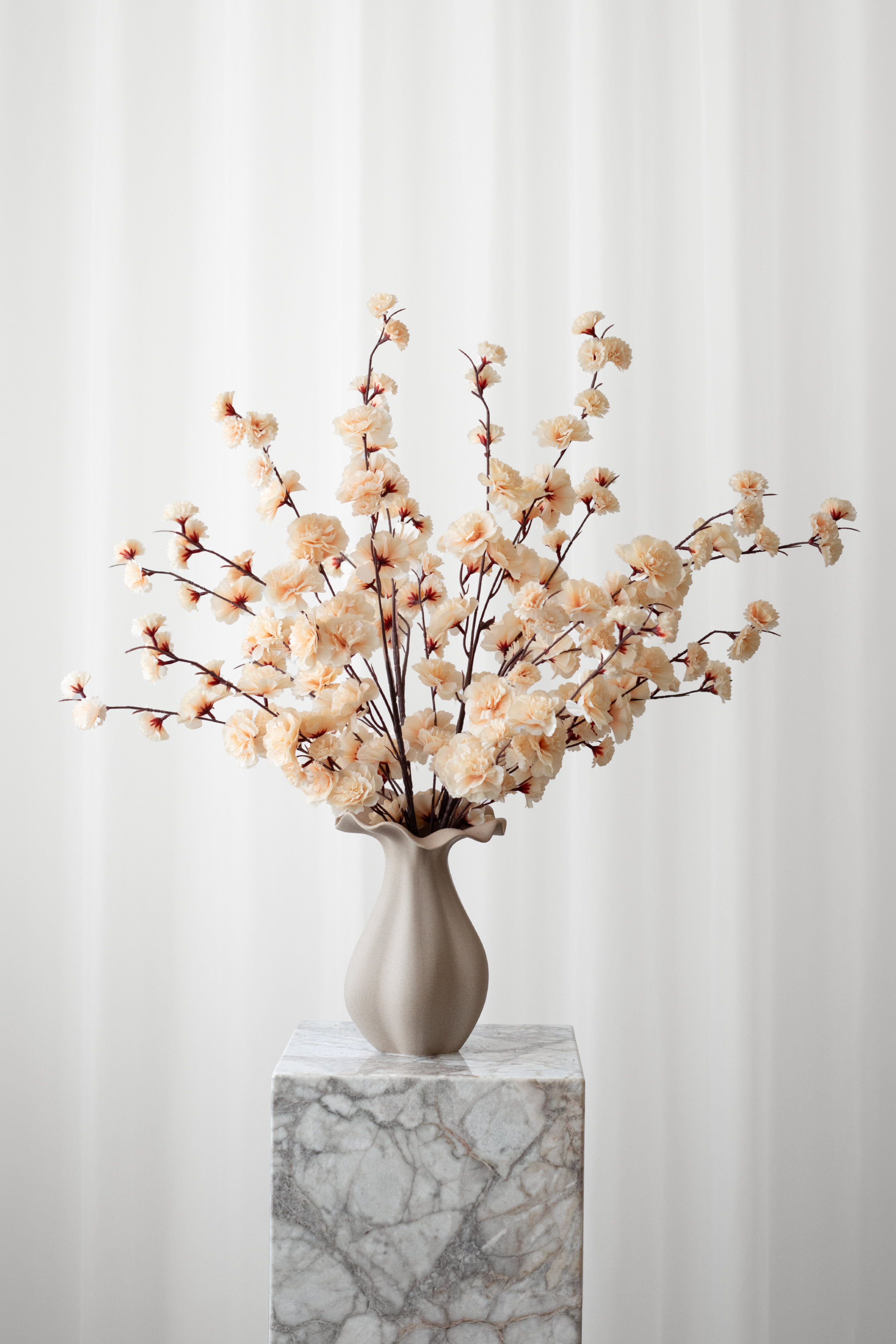 Buket af kunstige kirsebærgrene i champagnefarvet. Buketten er luftig, let og sommerlig i keramikvasen.