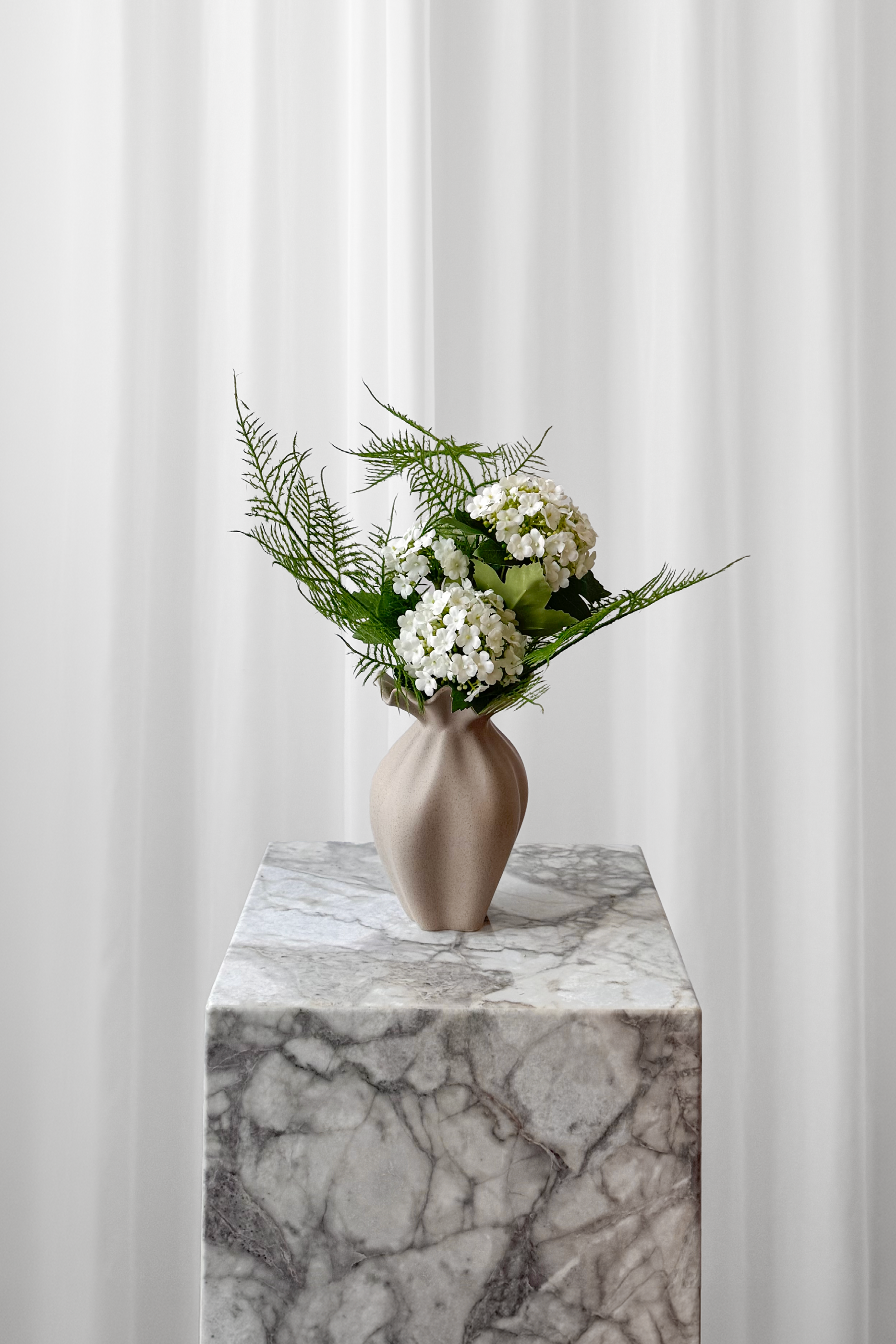 Lille buket i grøn og hvid, stylet i den lille Nellie keramikvase. Naturtro kunstige blomster fra Specktrum.