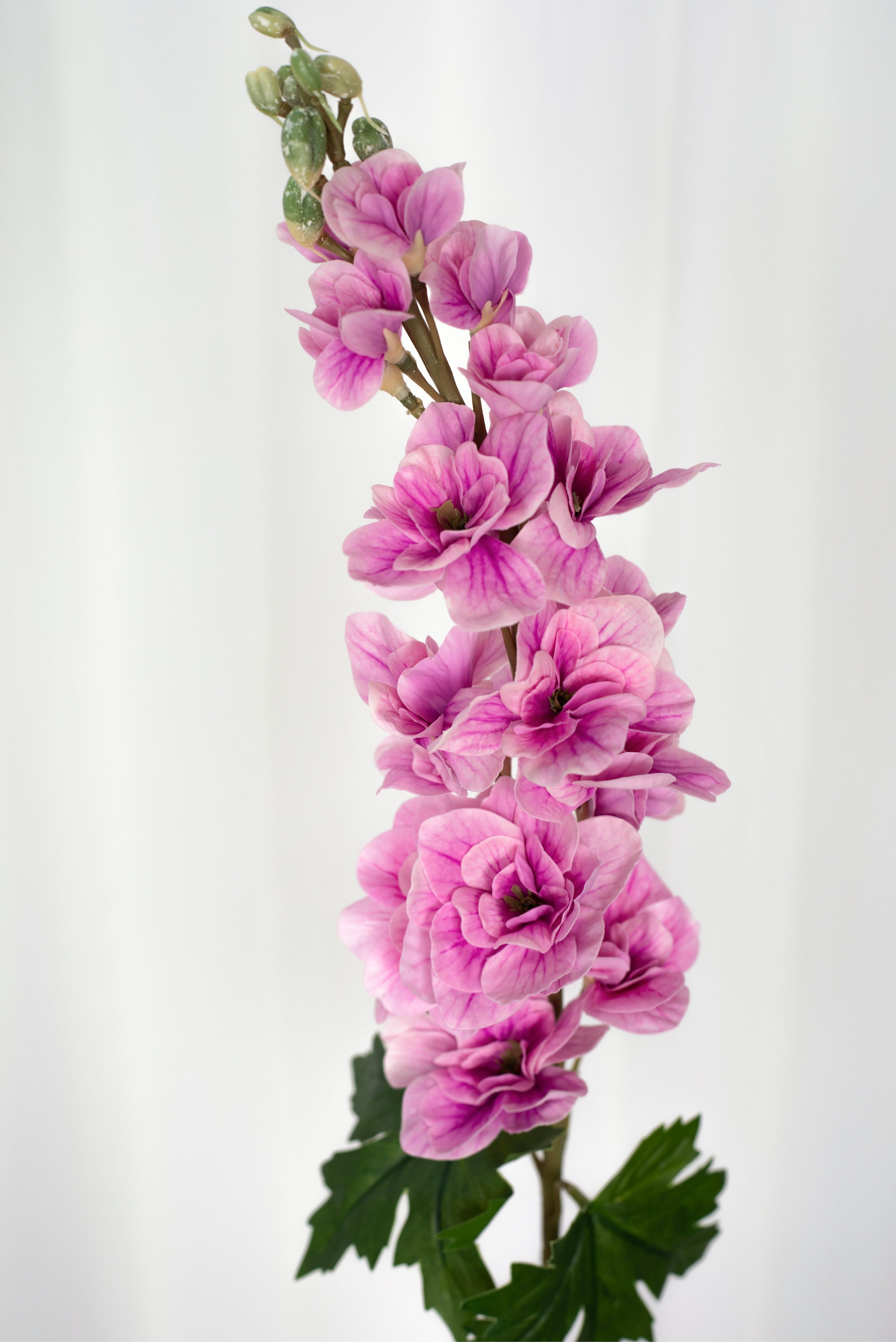 Detaljebillede af kunstig consolida blomst i pink.