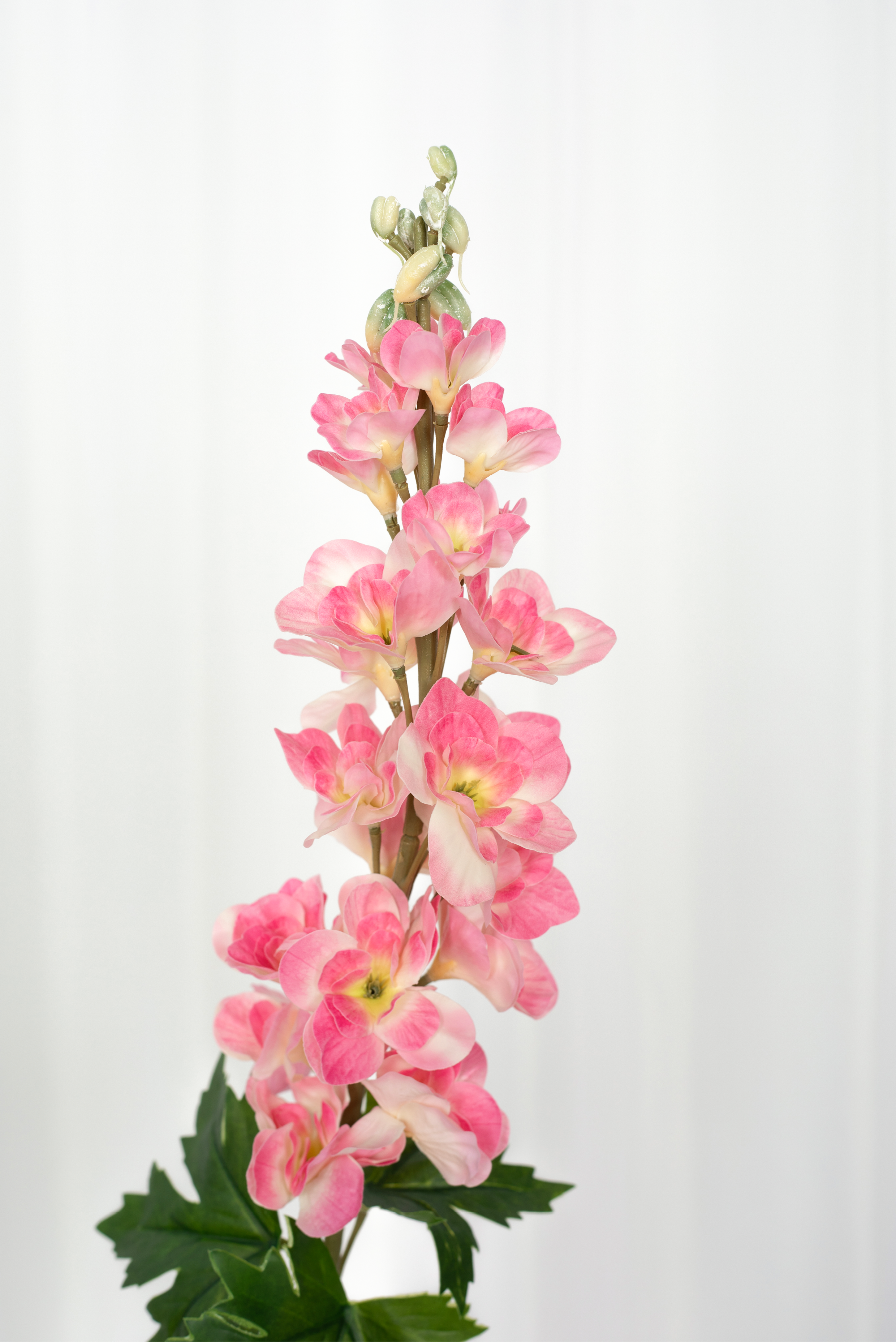 Detaljebillede af kunstig consolida blomst i rosa.