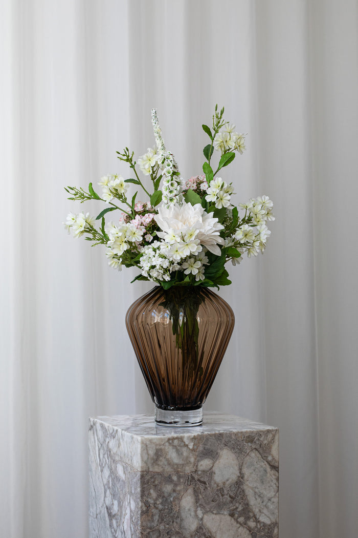 Lys og luftig buket til en særlig person, der fortjener blomster. Blomsterne er stylet i en brun glasvase fra Specktrum.