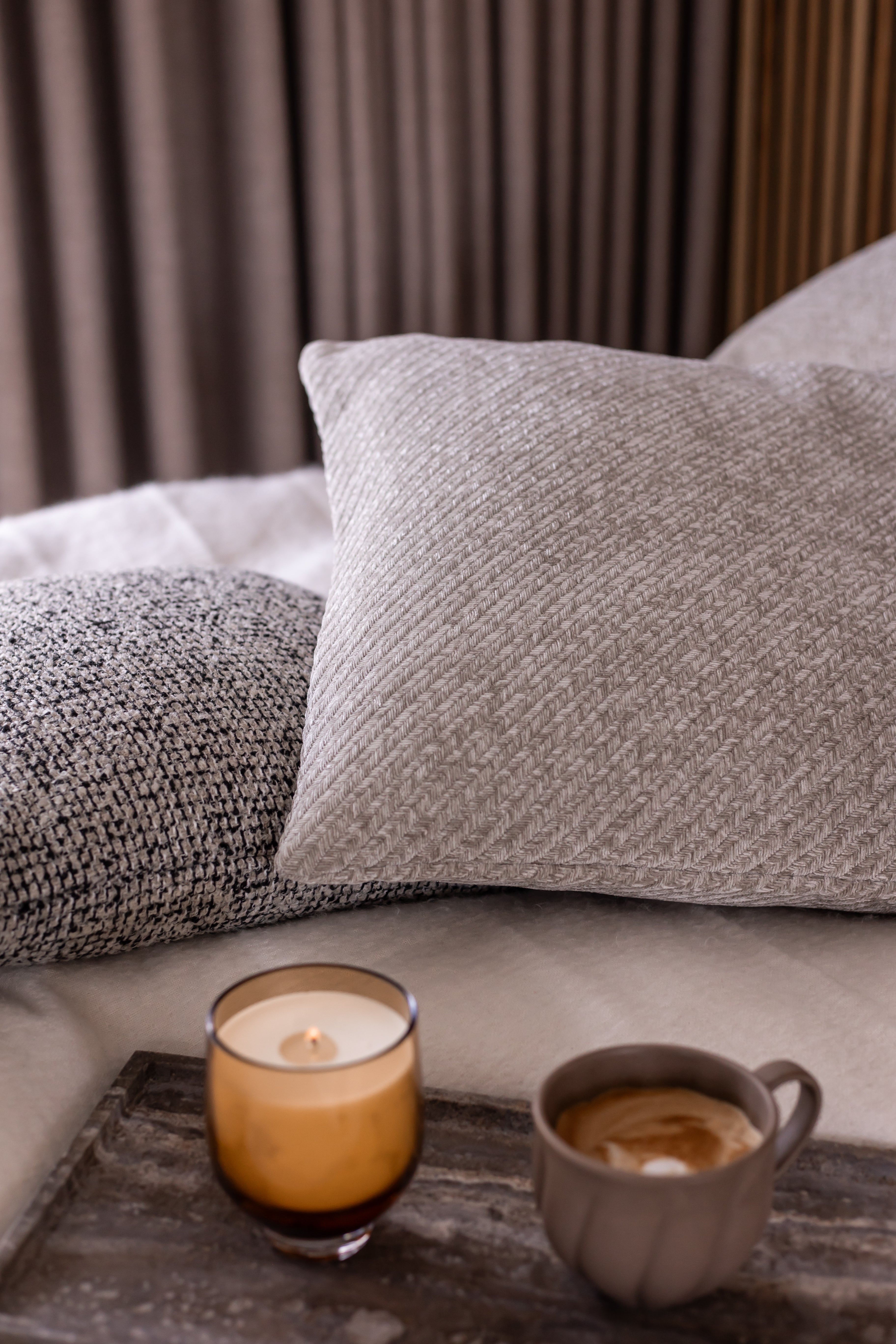 Pude med herringbone mønster fra Specktrum arrangeret i sengen for en hyggelig stemning.