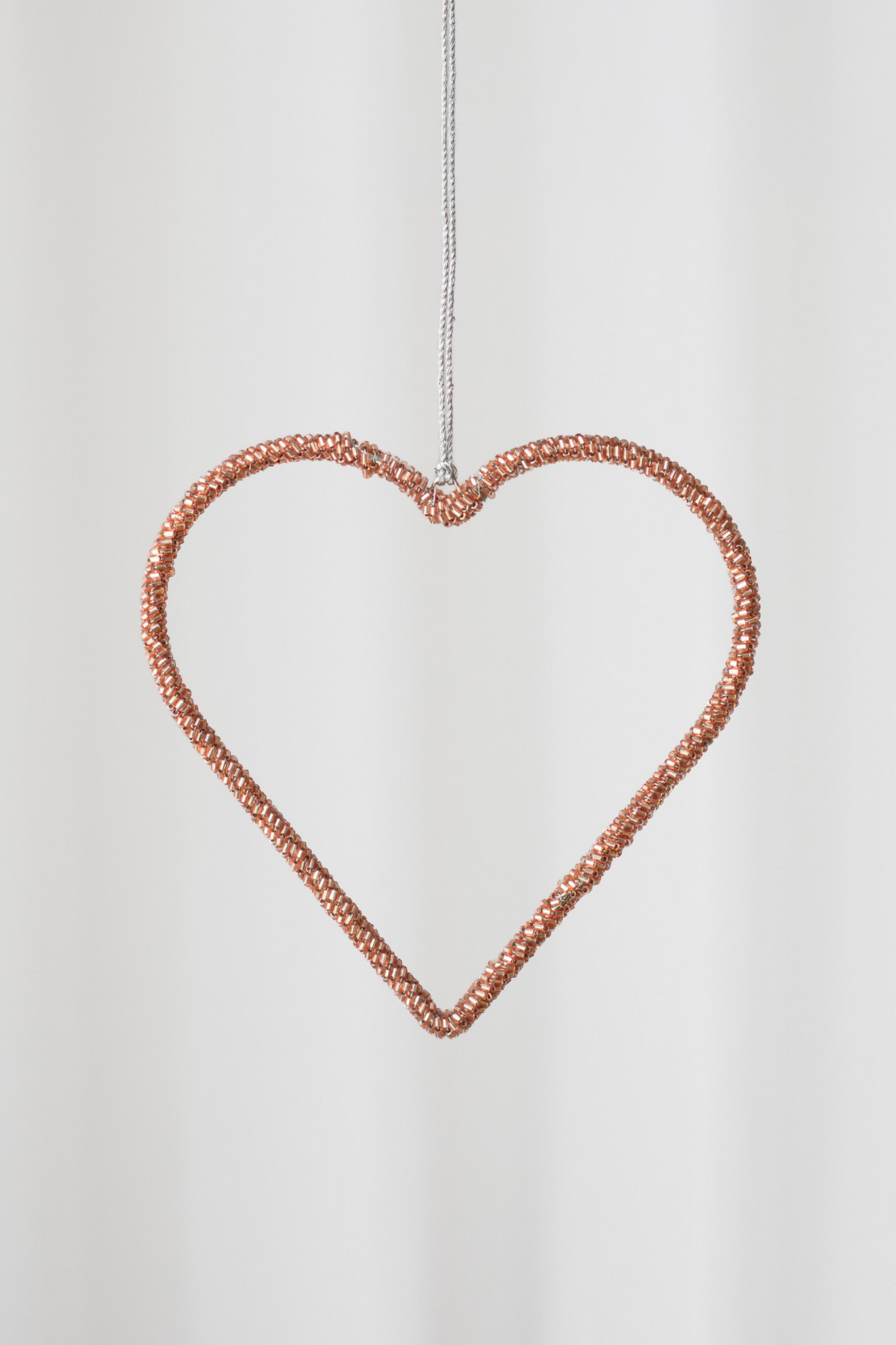 Stort hængende hjerte af rosa perler.