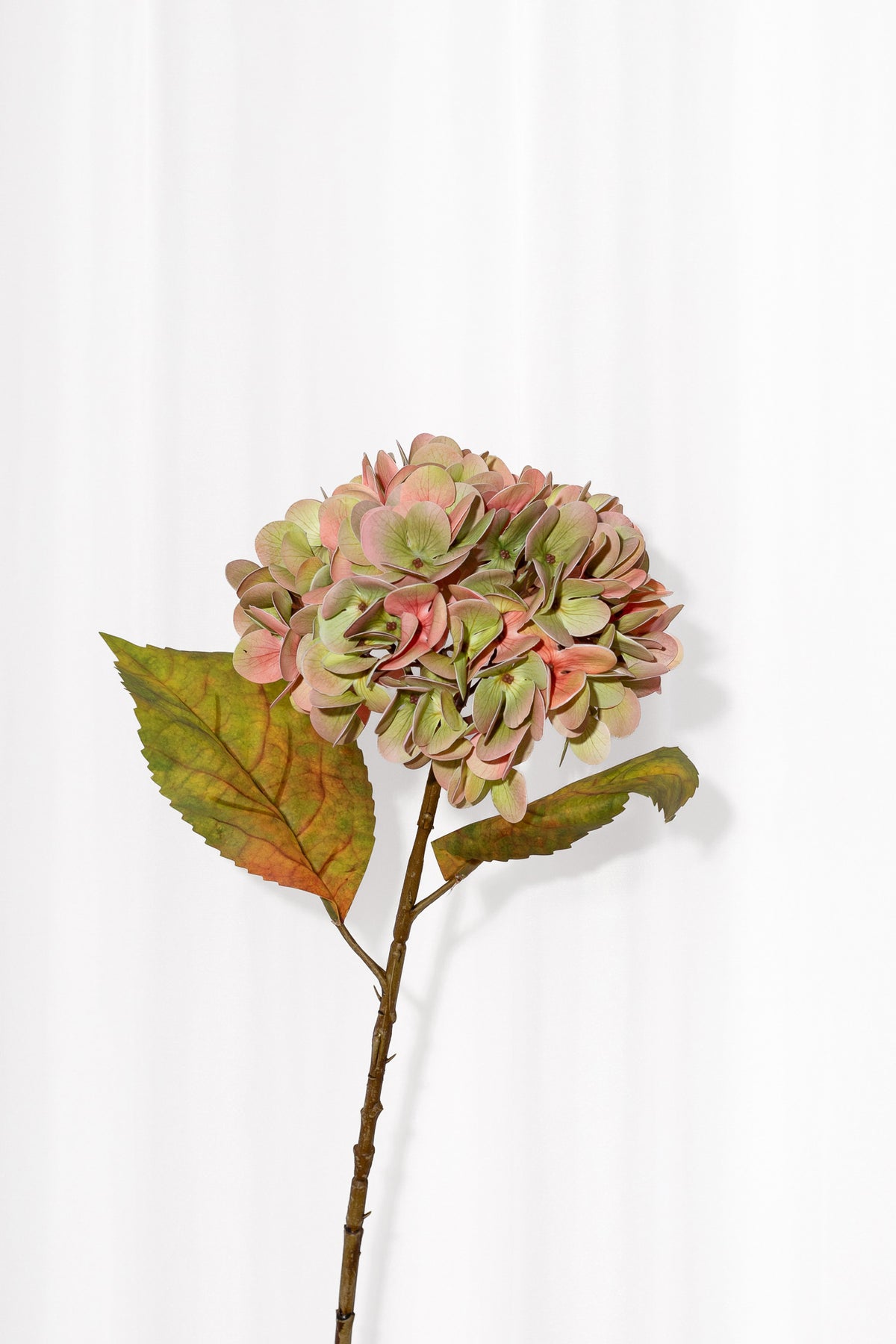 Kunstig hortensia blomst i lyserøde og grønne nuancer, der passer perfekt til efterårets buketter. Blomsten er yderst naturtro.