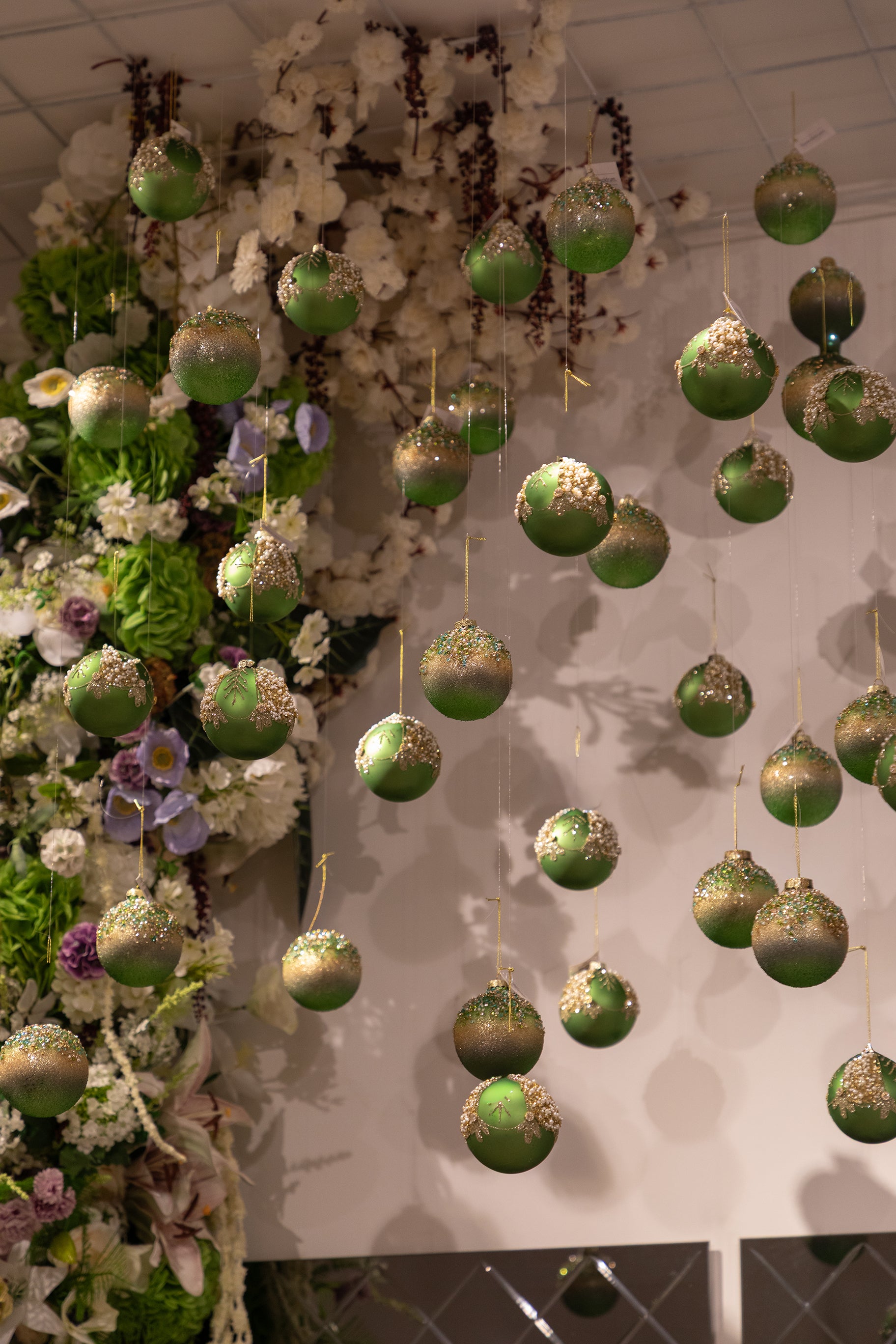 Grønne julekugler, der hænger ned fra loftet.