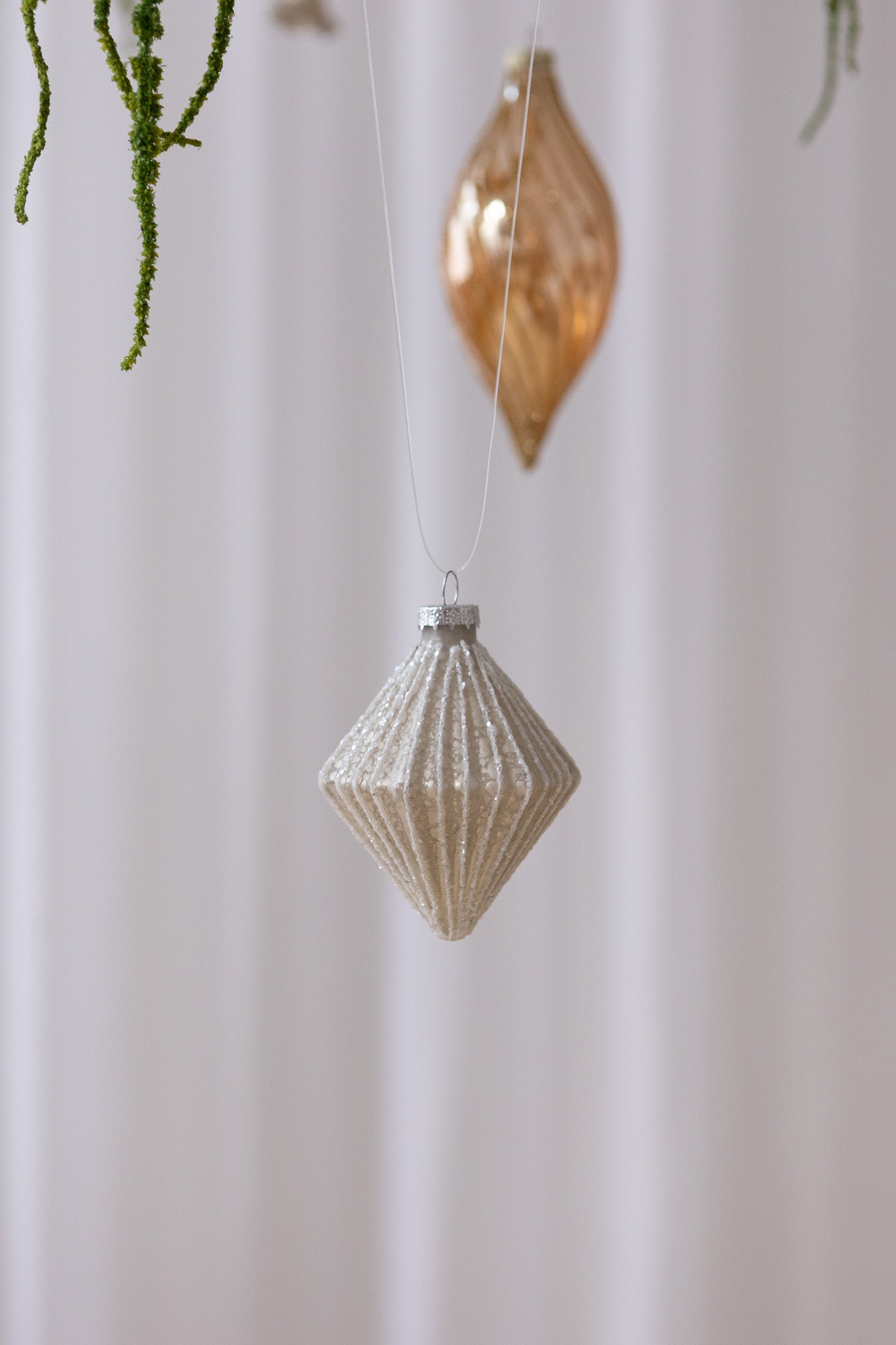 Billede af Rudeformet julekugle i beige antik og med hvid glimmer.