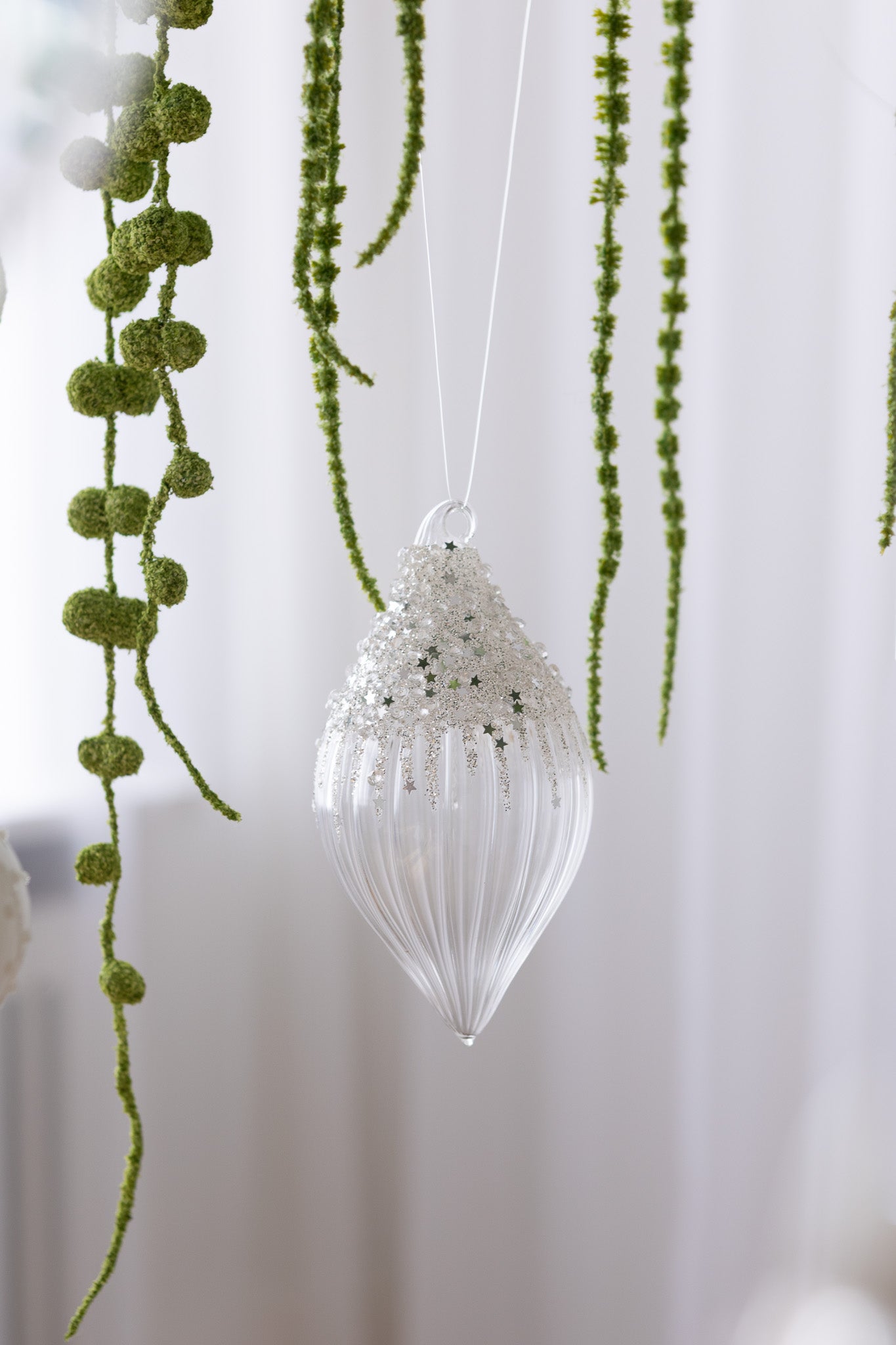 Nærbillede af Aflang julekugle i klar glas med sølv glitter og perler i toppen