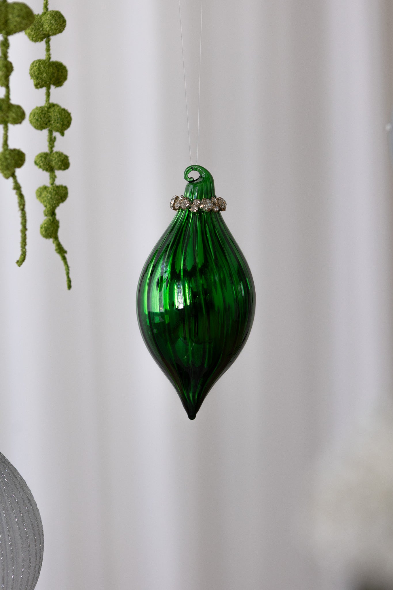 Nærbillede af Aflang julekugle i grøn med linjer og krystaller i toppen