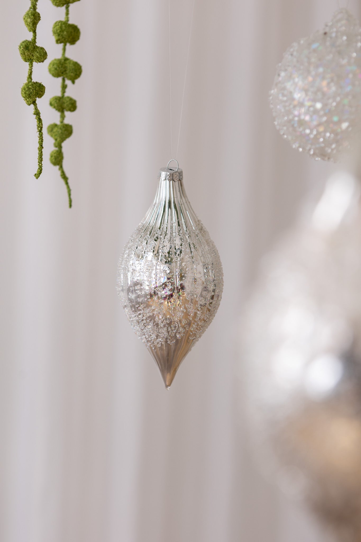 Nærbillede af Aflang glasjulekugle i sølv med swirl mønster og frost mønster