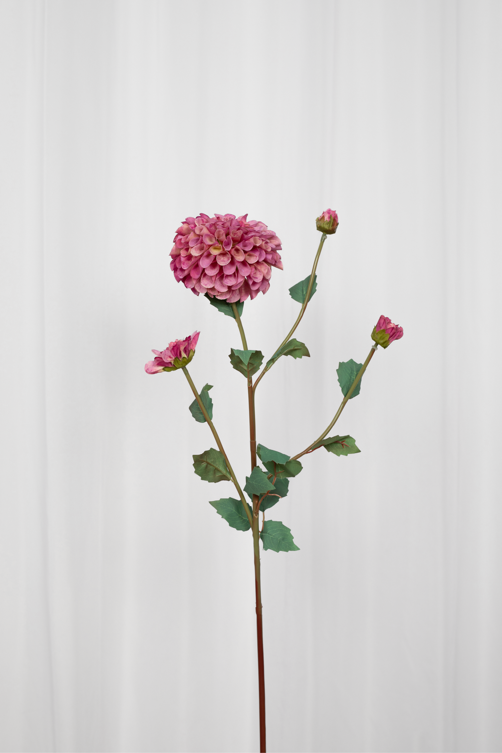 Kunstig dahlia blomst i pink med grønne grene.