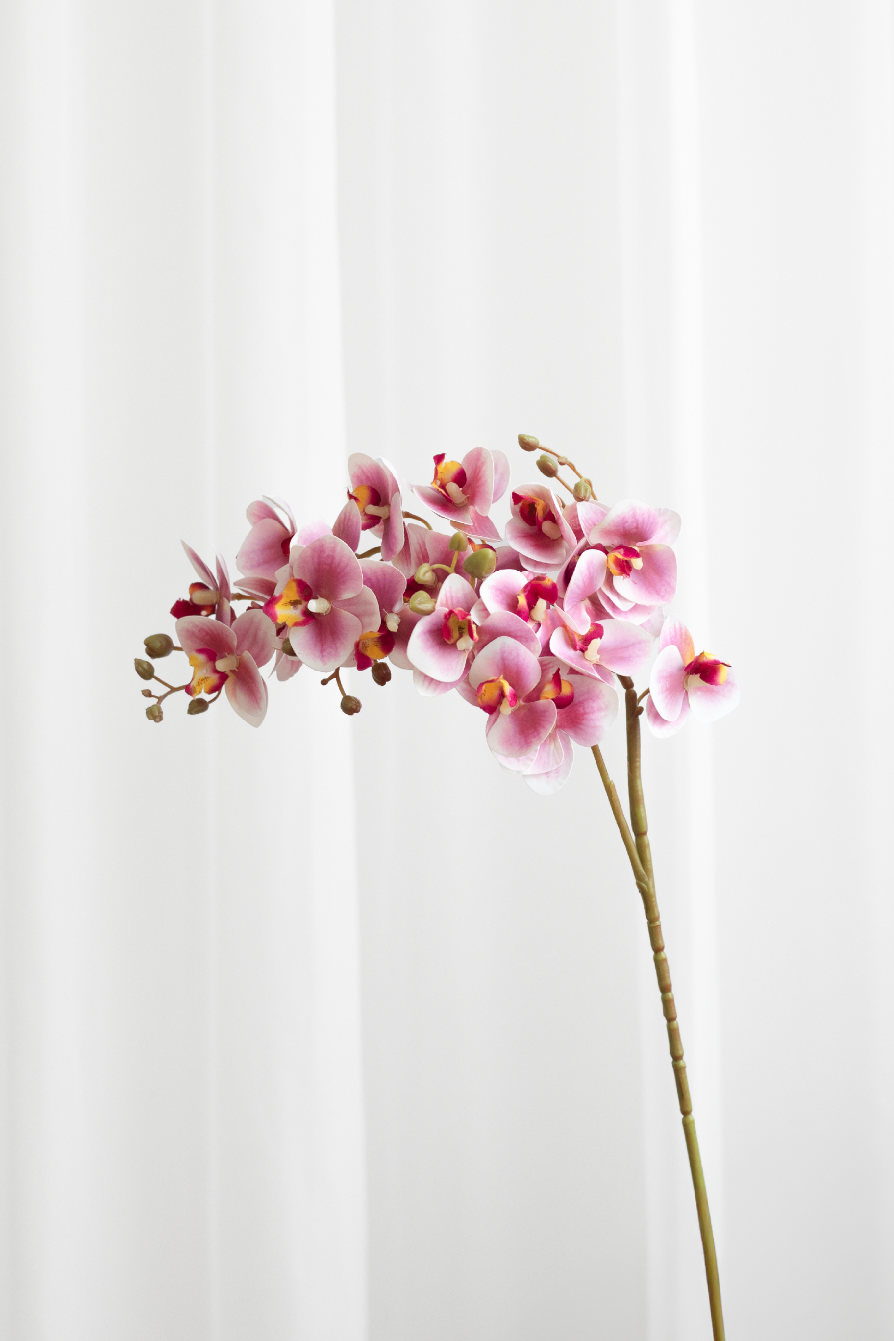 Kunstig orkide i pink med 21 blomsterhoveder.