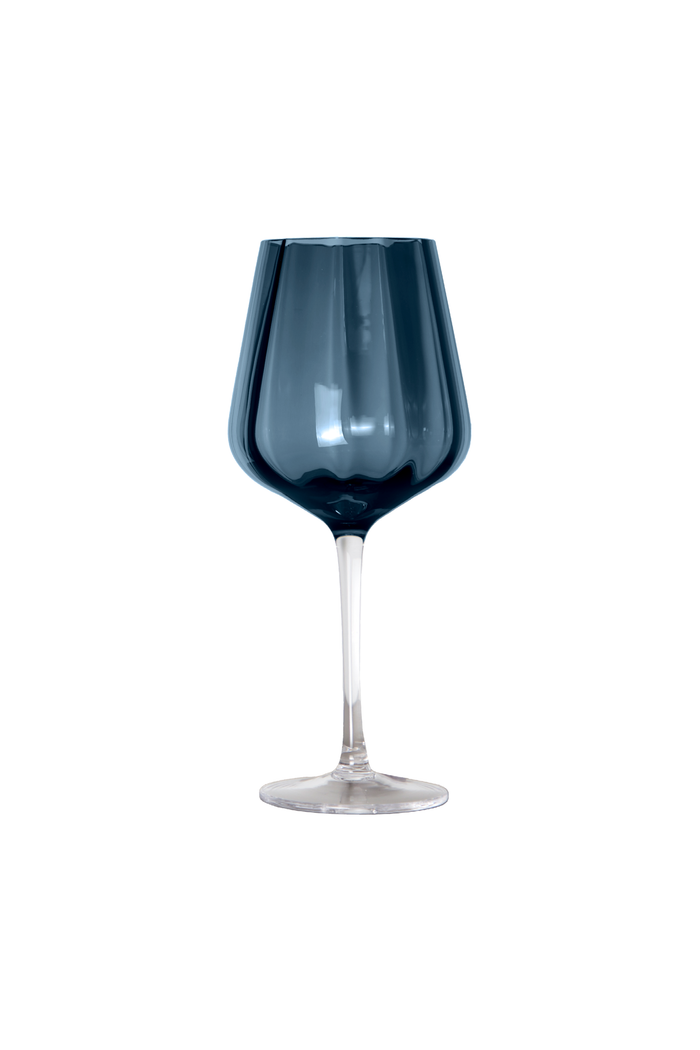 Produktfoto af et Meadow vinglas i en dyb blå farve. Glasset har en facetteret overflade, en klar stilk og en bred fod. Glasset er centreret mod en hvid baggrund, hvilket fremhæver designet og farvedetaljerne.