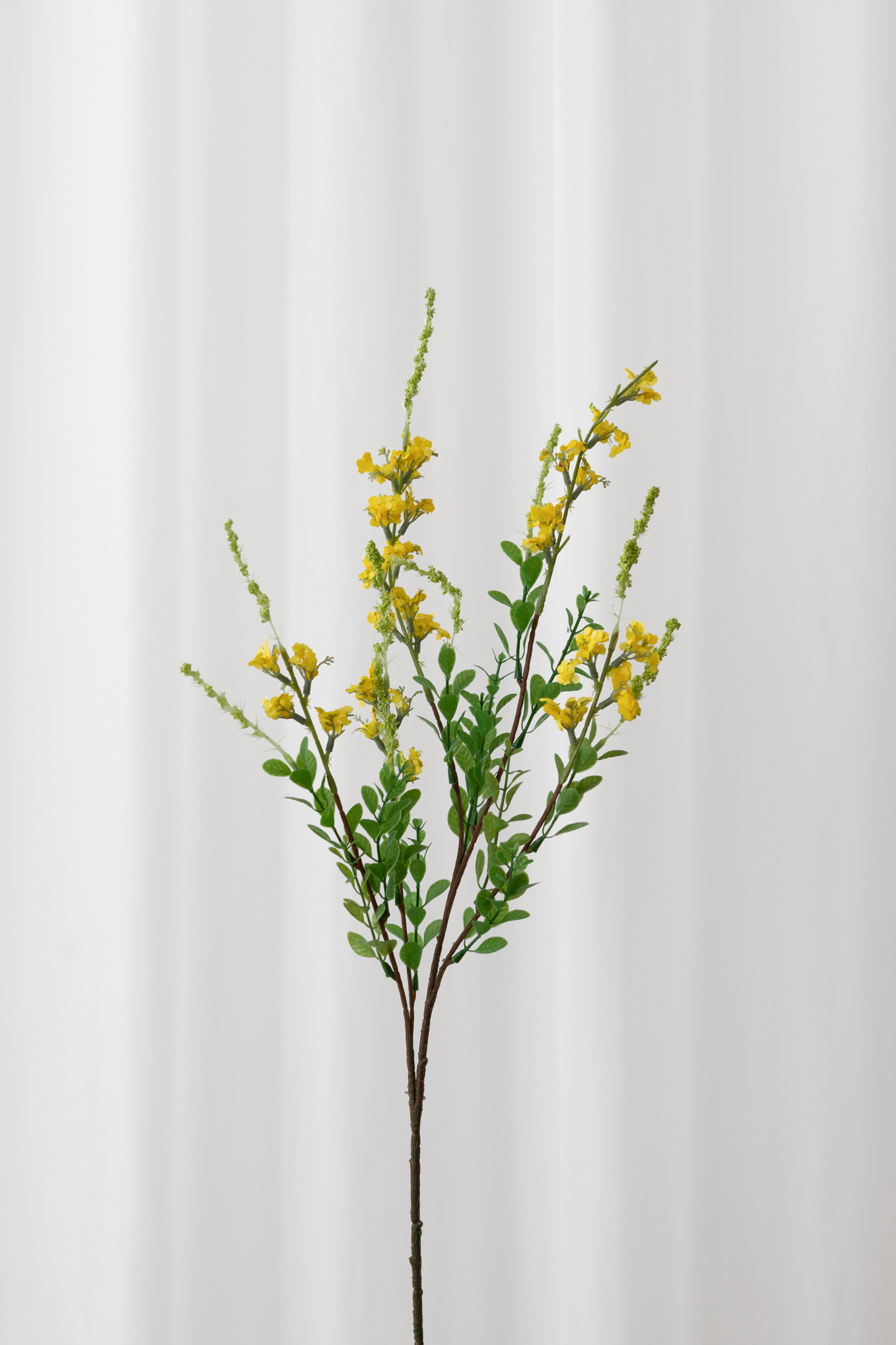 Kunstig sage gren i gul med grønne blade og naturtro detaljer og udseende.