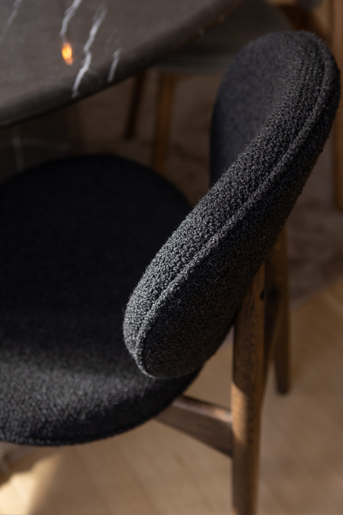 Nærbillede af FSC-certificeret spisebordsstol fra Specktrum i mørkolieret egetræ med sort polstring.