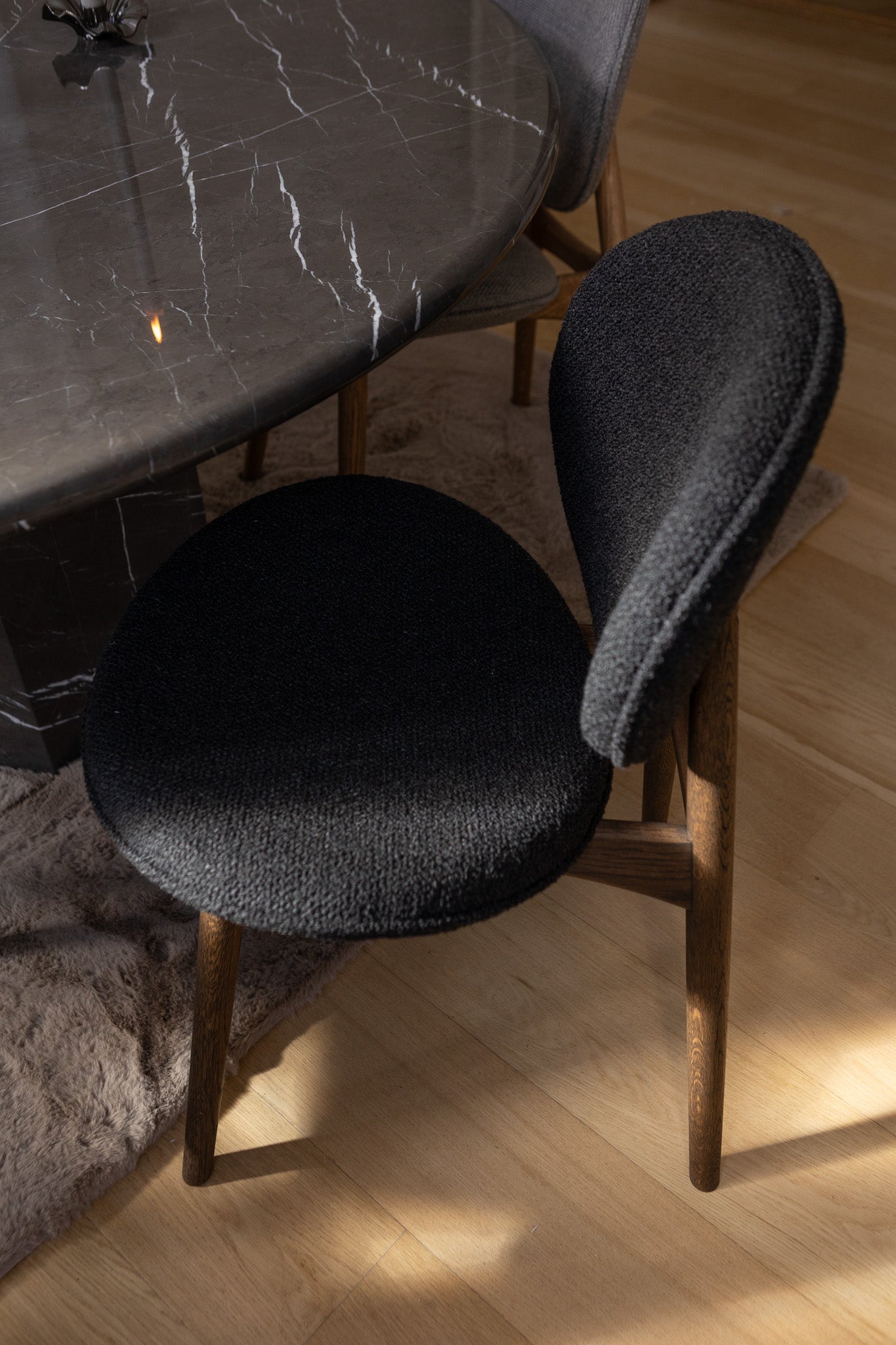 Nærbillede af FSC-certificeret spisebordsstol fra Specktrum i mørkolieret egetræ med sort polstring.