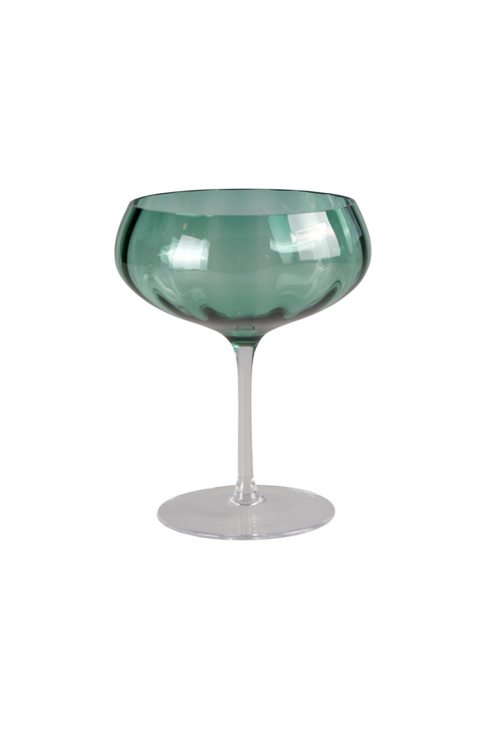 Et grønt cocktailglas i transparent glas med bred skål og lang stilk.