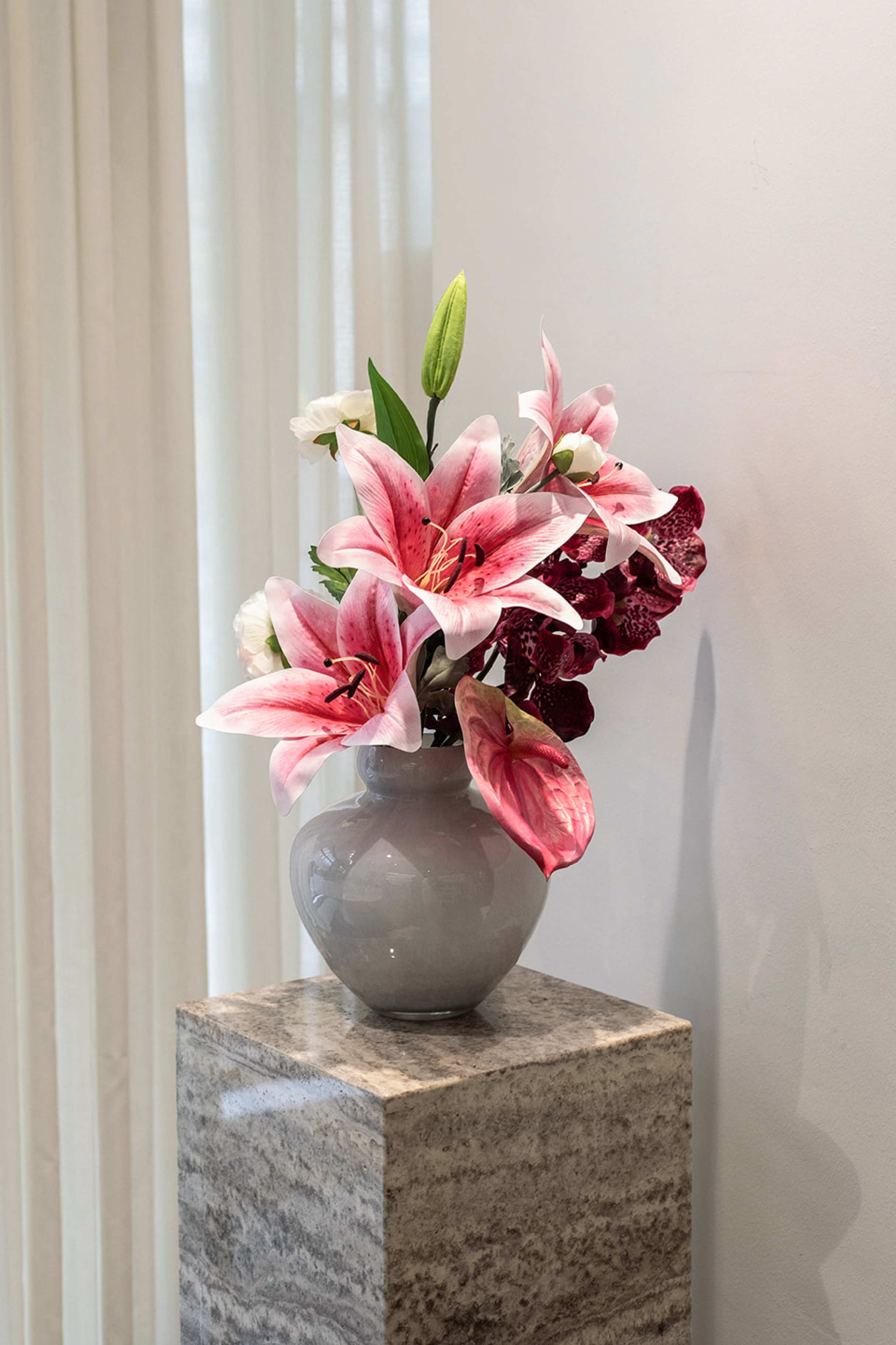 Kunstige blomster samlet til buket.
Buketten er stylet i den mundblæste Mateo vase i grey.
Buketten indeholder:
1 x Light rose ranunculus
1 x Plum Orchid (7 heads)
1 x Rose lily large
1 x Rose anthurium