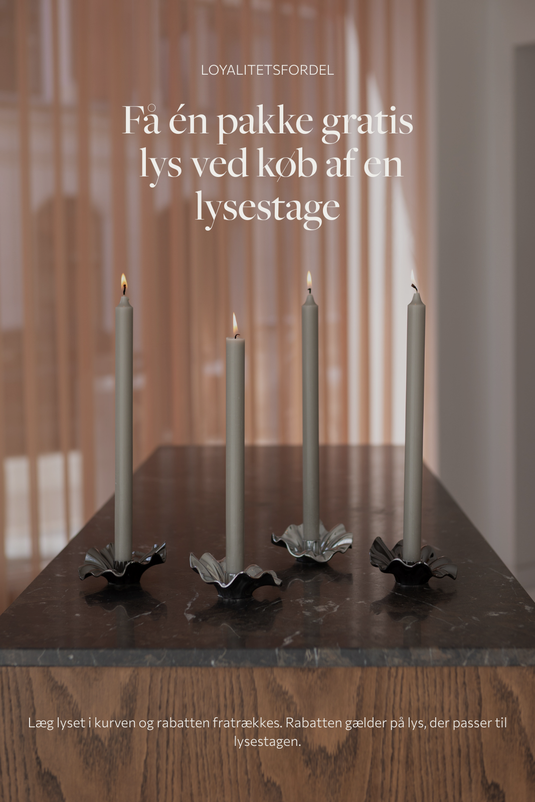 Loyalitetsfordel - få en pakke lys ved køb af en lysestage. Fire lysestager med grå stagelys der står på et køkkenbord.