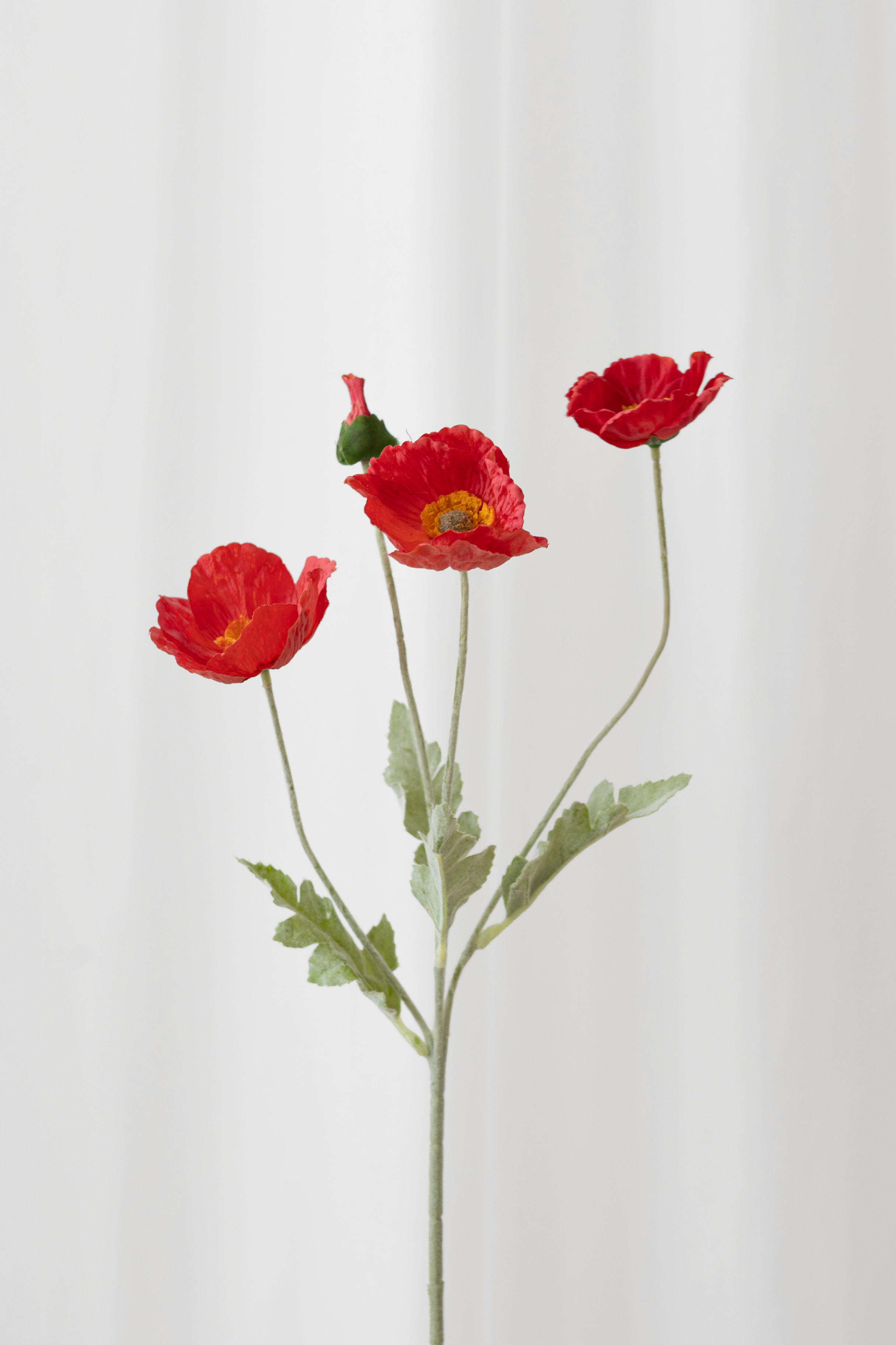 Naturtro kunstig valmue i røde toner.