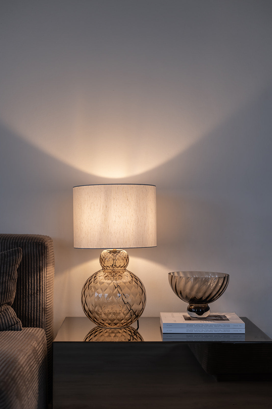 Brun lily bordlampe med harlequin mønster og hvid sylvester lampeskærm. Står på et sidebord.