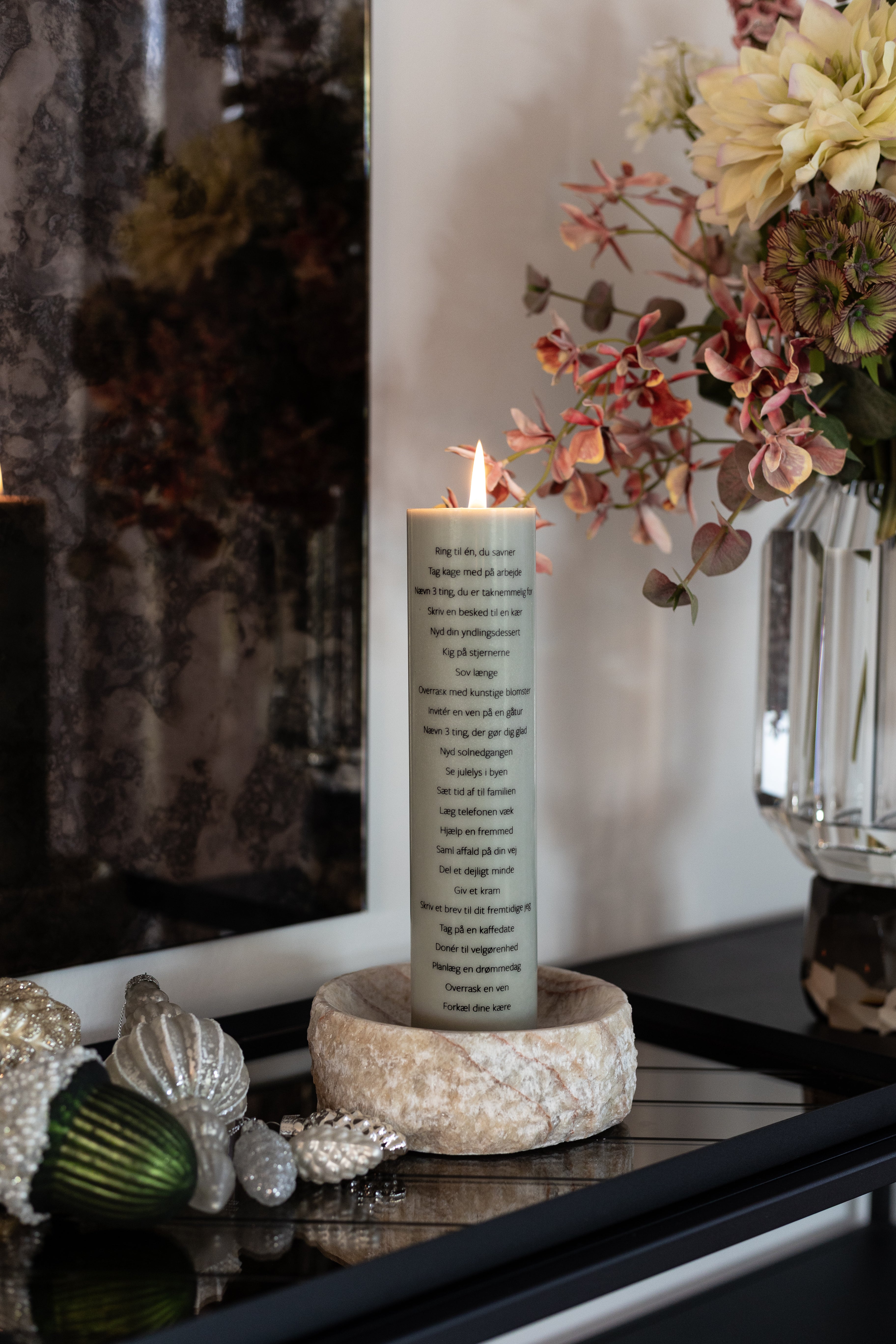 Støvet grønt kalenderlys fra Specktrum stylet i Ivy skålen ovenpå en spejlbakke.