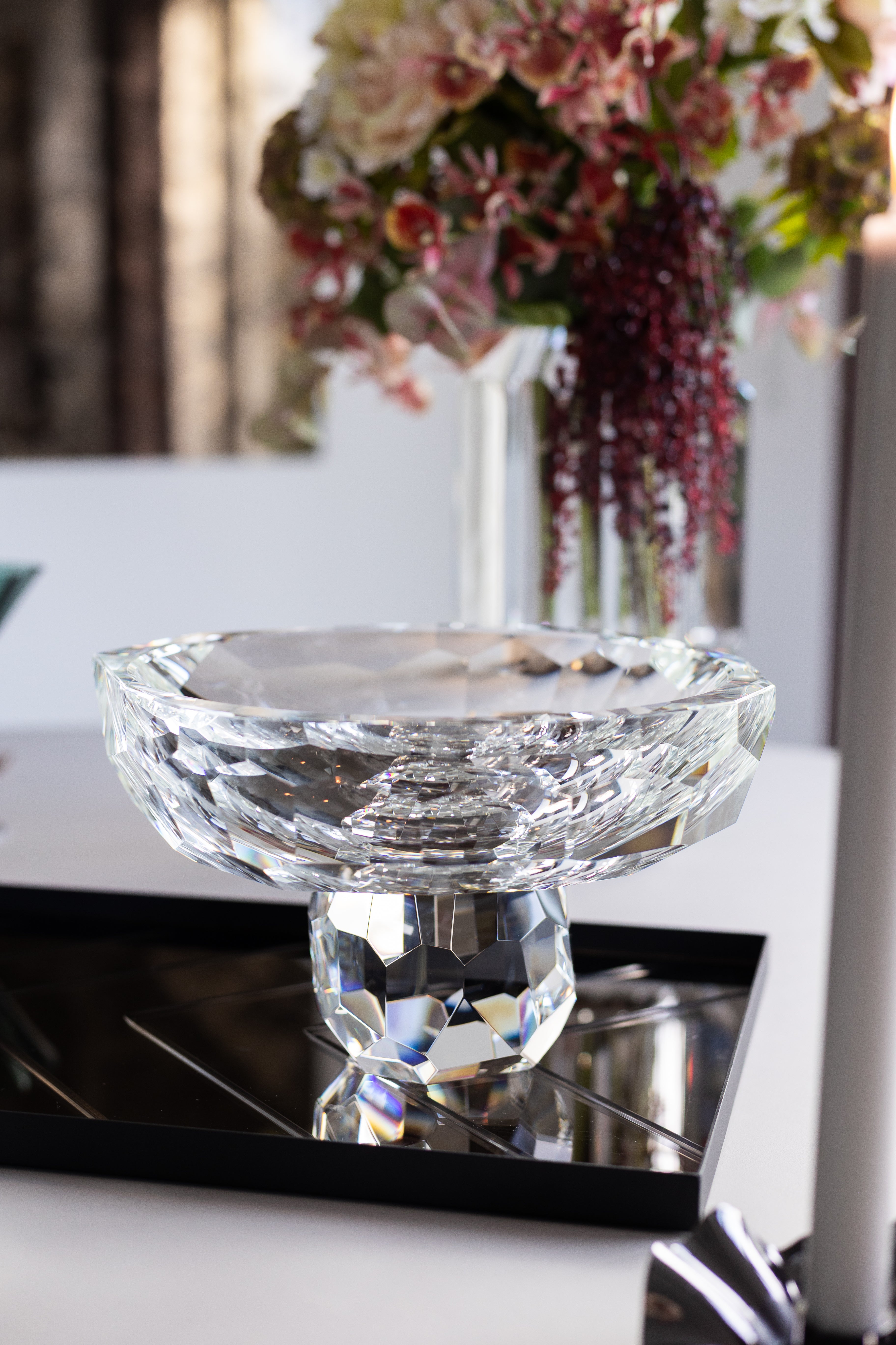 Stormskålen i klar krystalglas stylet på en spejlbakke på et spisebord.