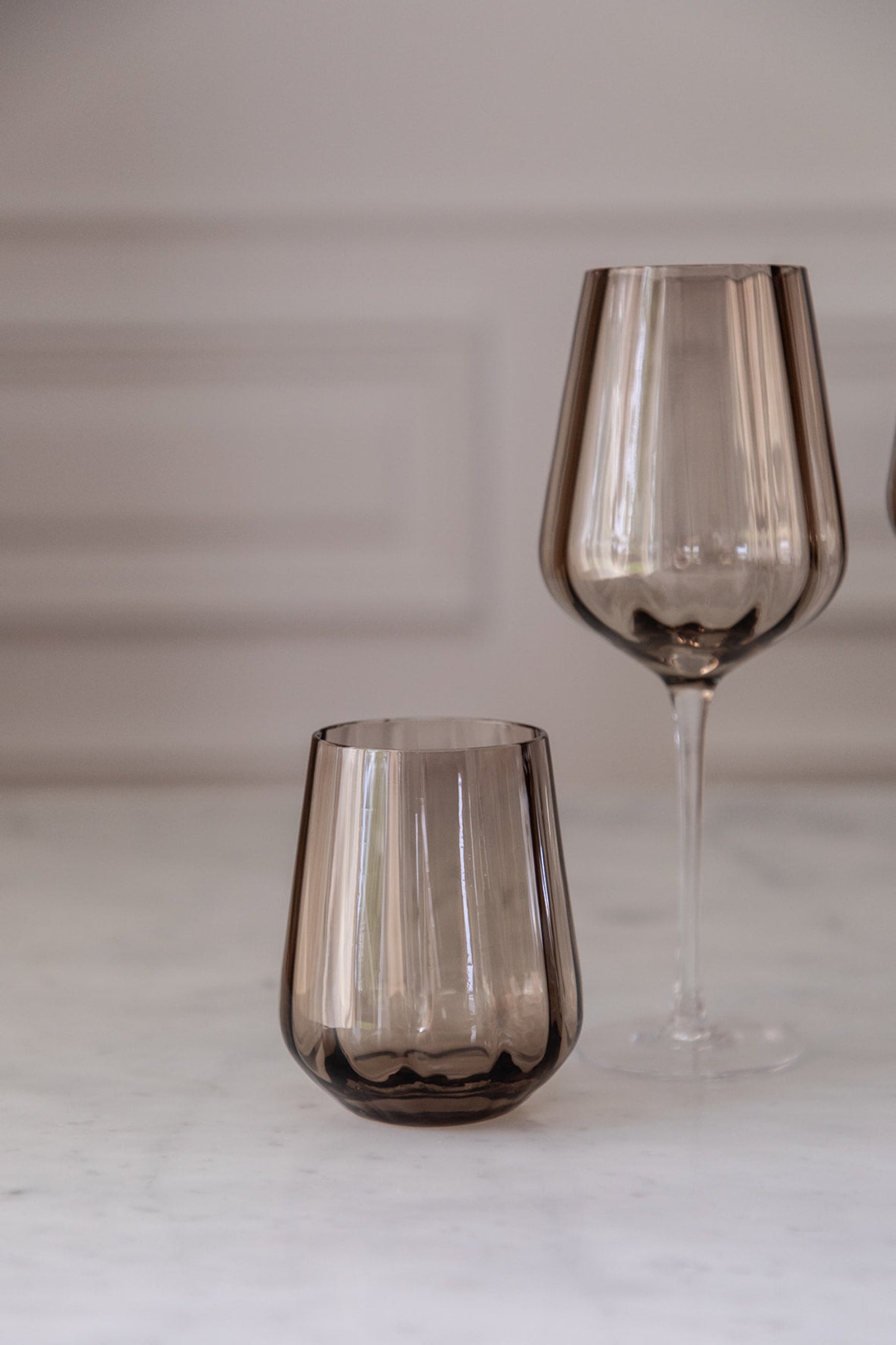 Drikkeglas i en brun farve sammen med et hvidvinsglas i samme farve.