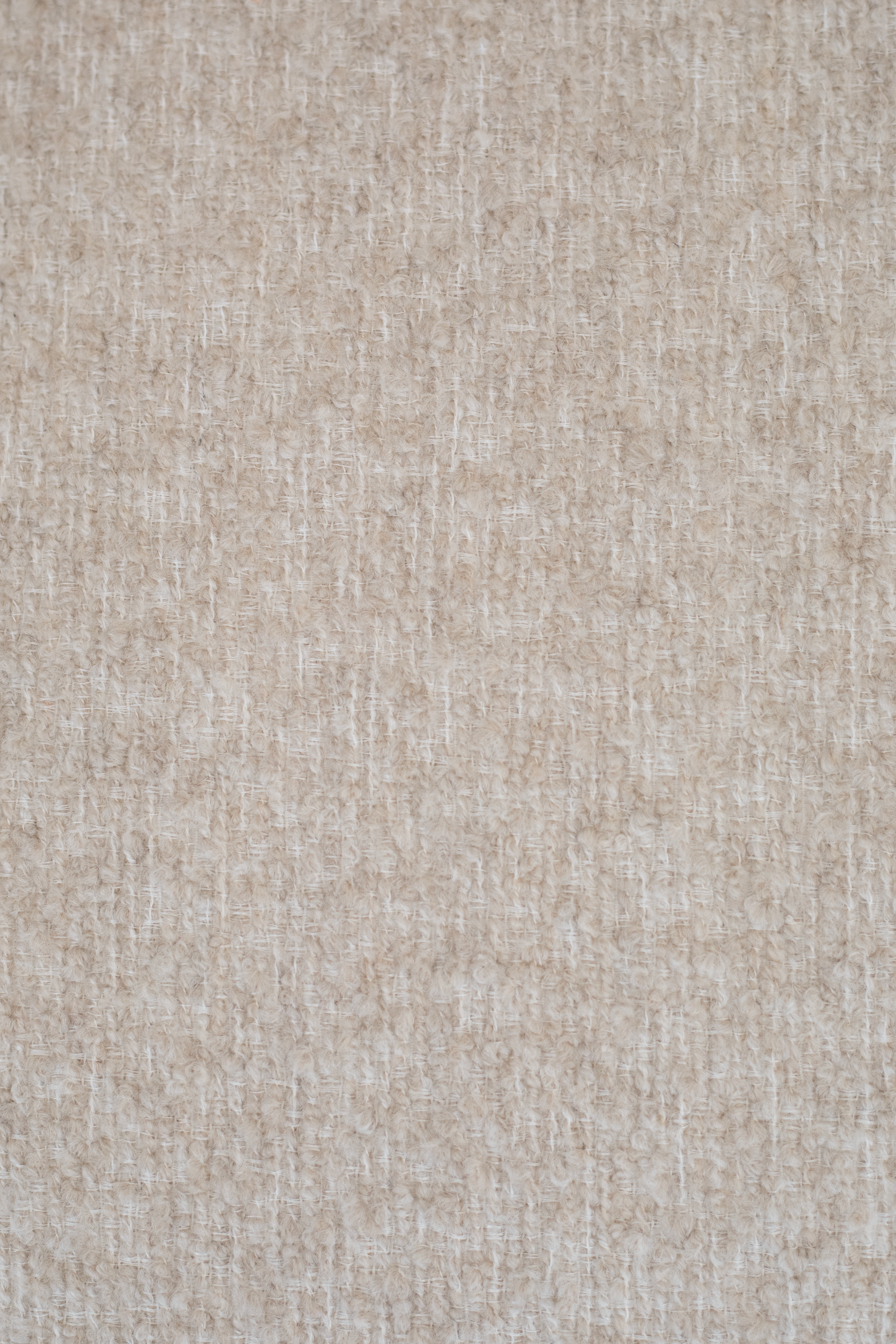 Detalje af Olivia loungestol i sand bouclé med synlig tekstur