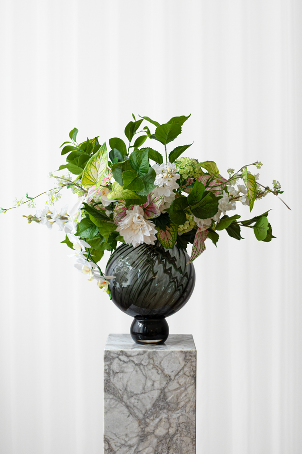 Buket Grøn Oase er skabt af grønne, hvide og rosa blomster. En kunstig blomsterbuket, der ser luftig og naturlig ud. Den bundne buket er fra Specktrum. 