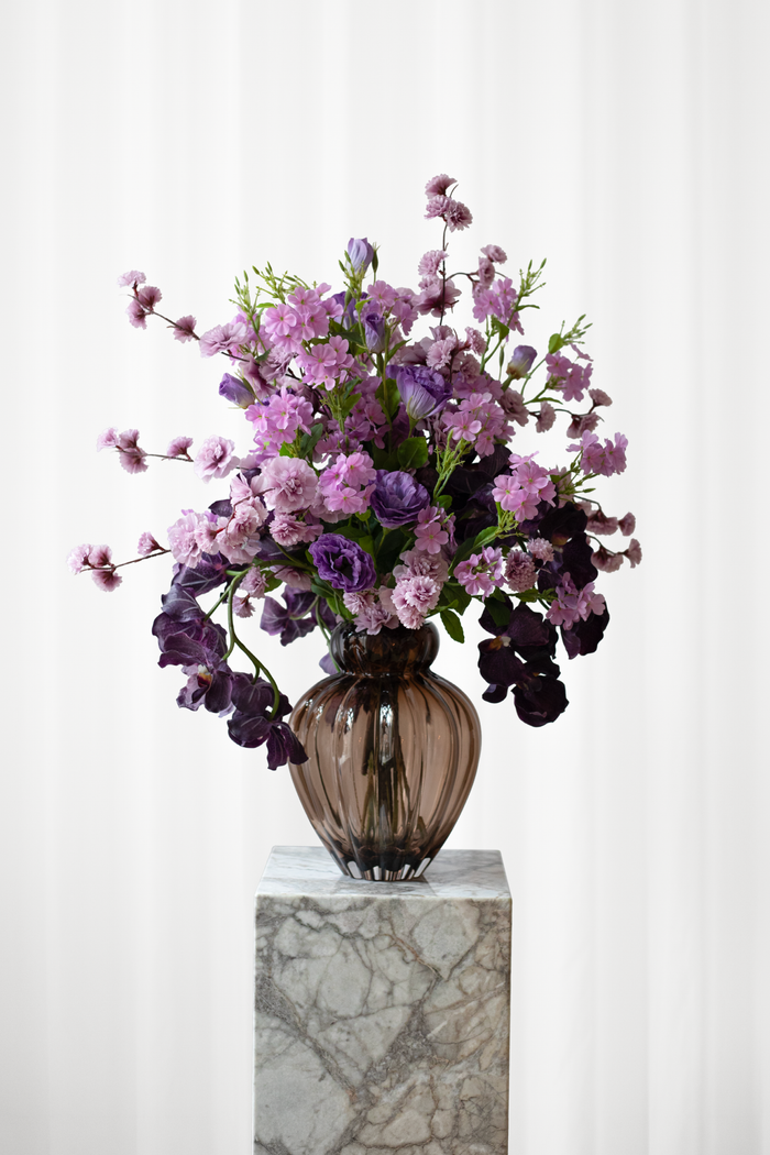 Stor buket af kunstige blomster i smukke, lilla farver. Blomsterne har real touch effekt, og føles ægte.