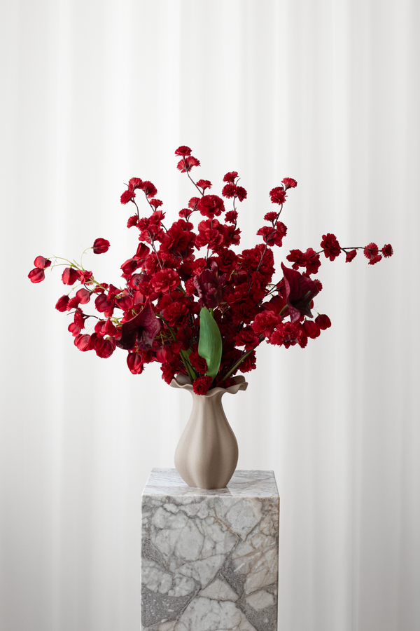 Buket i røde nuancer af kunstige blomster med naturtro detaljegrad. Blomsterne er fra Specktrum.