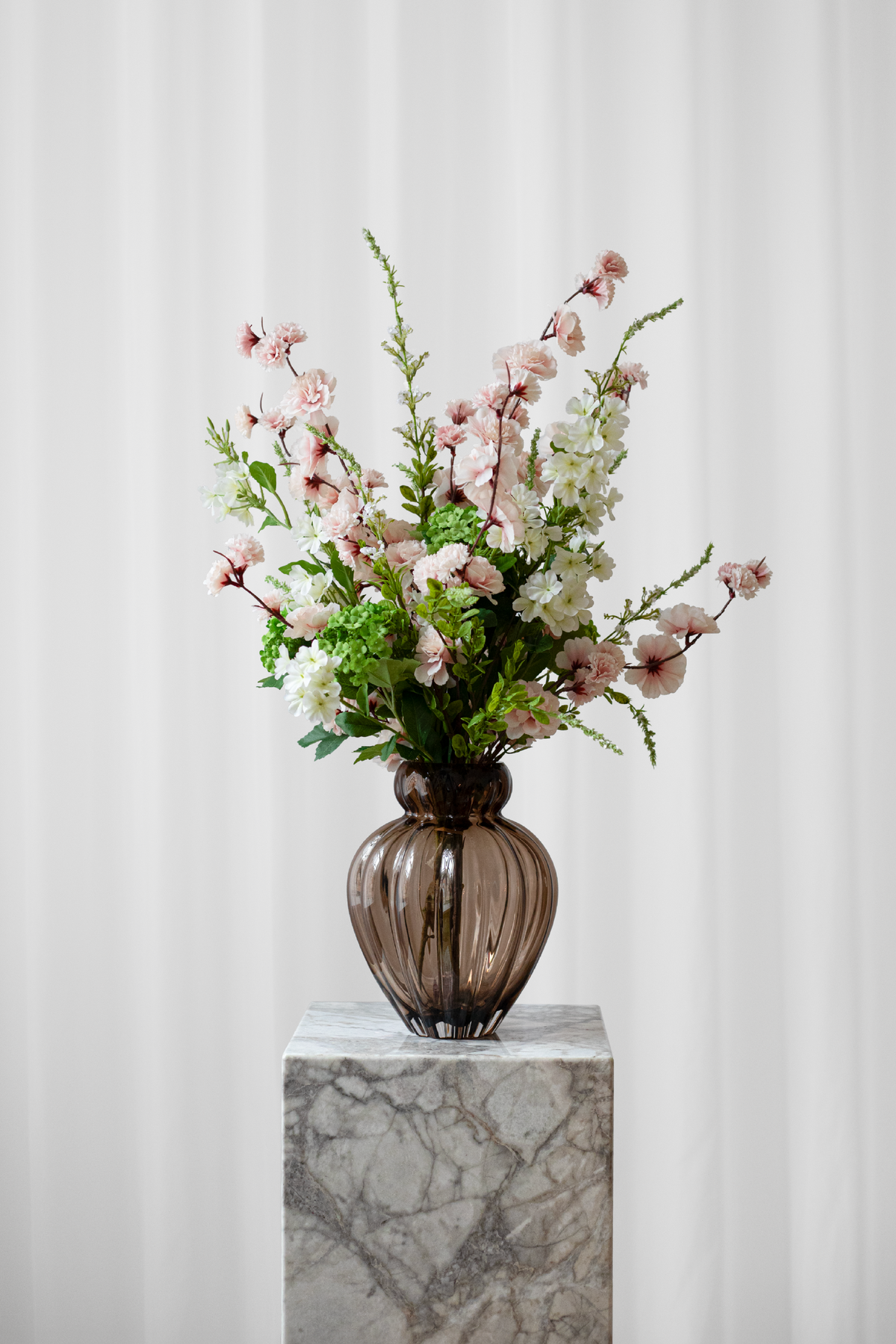 Smuk buket af kunstige, naturtro blomster i lyse farver.