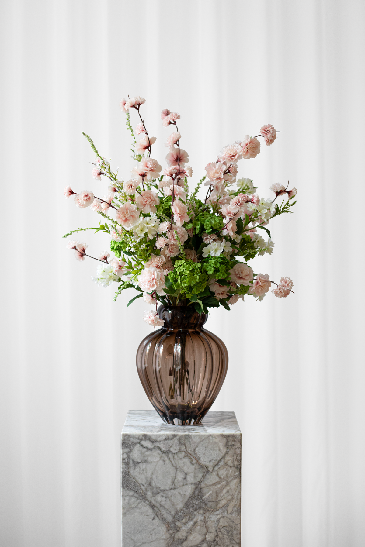 Stor, kunstig buket af naturtro blomster i lyserøde, hvide og grønne farver.