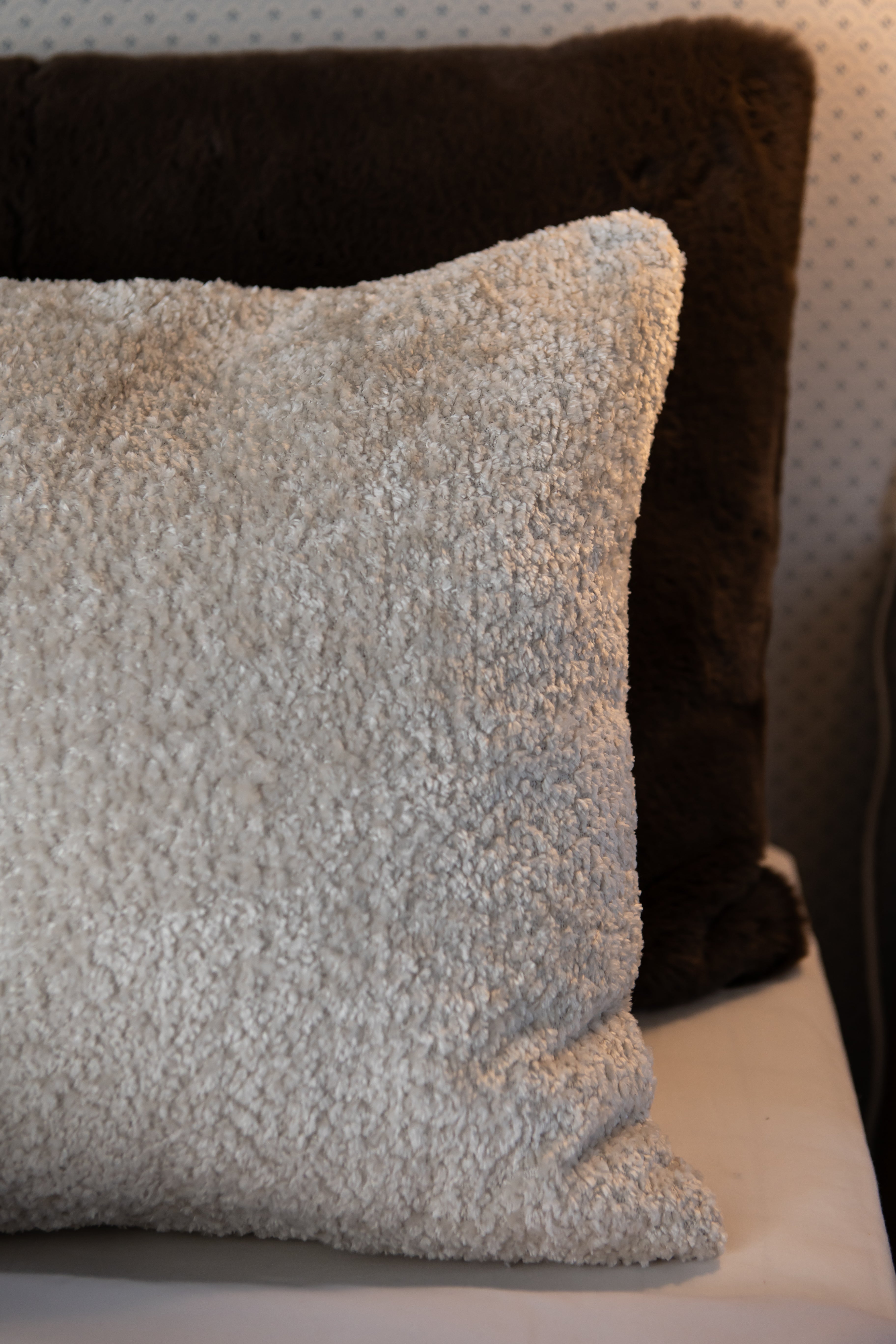 Detaljebillede af Karl puden med sin bløde overflade og creme farve. perfekt til at skabe hygge i soveværelset.