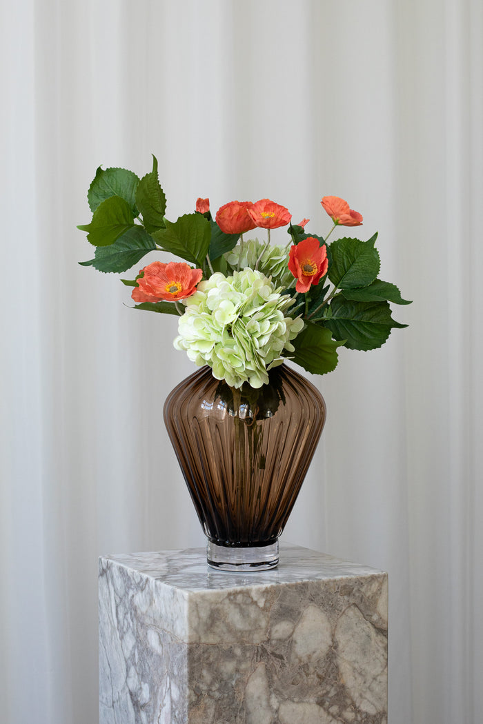 En kunstig buket, der siger "Jeg er her for dig" med hortensia, valmuer og bladgrene i grønne og rødlige farver.