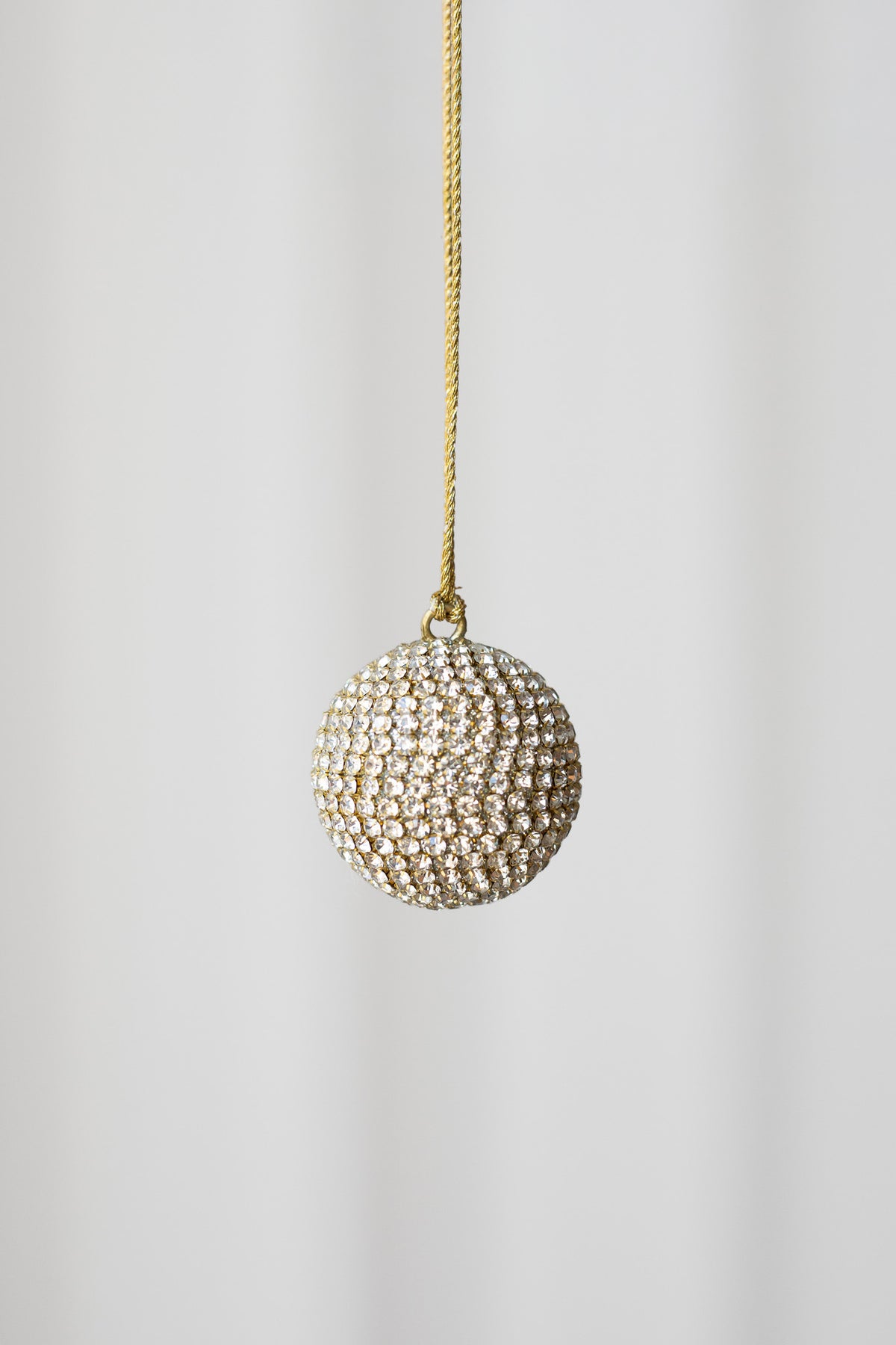 Lille julekugle i guld dækket med rhinsten. Julekuglen er fra Specktrum.
