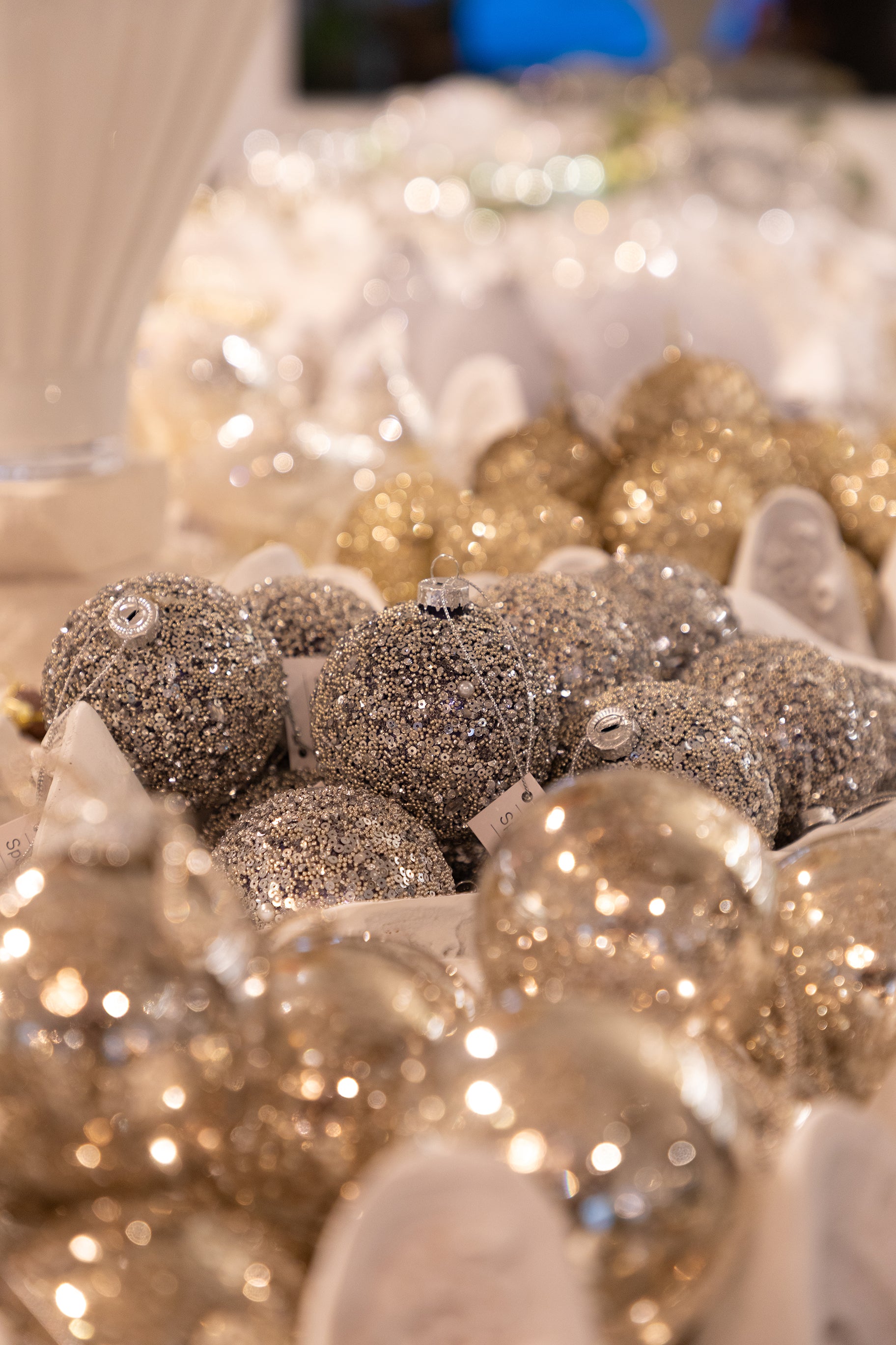 Julekugle med glitrende perle detaljer, der ligger i en musling skål.