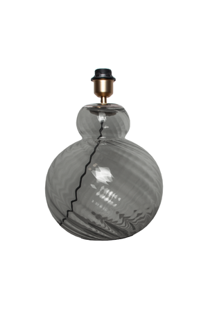 Bordlampe i gråtonet glas med buet, rund form og spiralformet mønster i overfladen. Lampen har en messingfarvet fatning og sort topstykke til montering af pære.