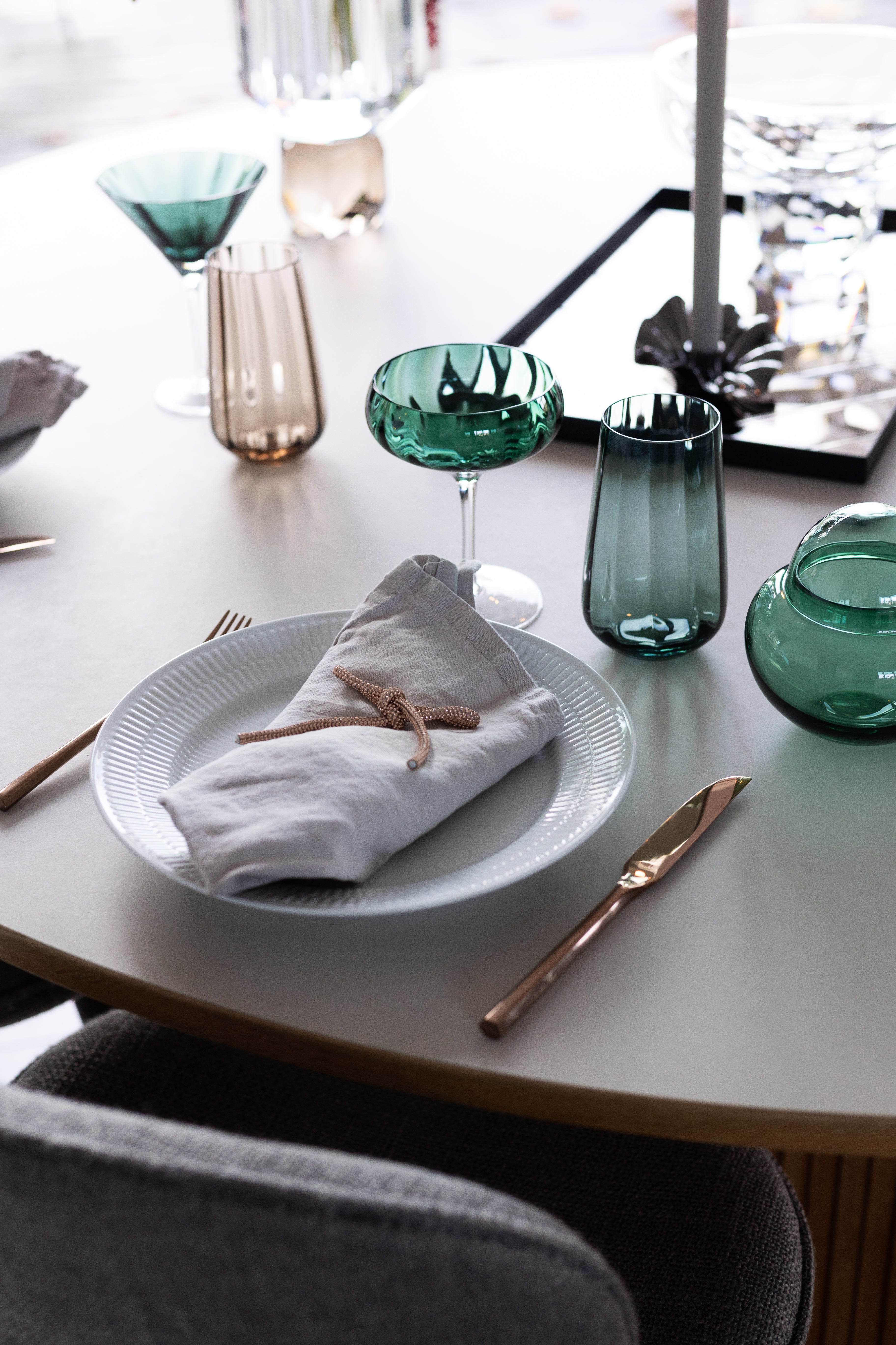 Højt drikkeglas fra Specktrum i mundblæst grønt glas med smukke riller. Glasset er en del af en smuk borddækning med andre glas fra samme Meadow kollektion.