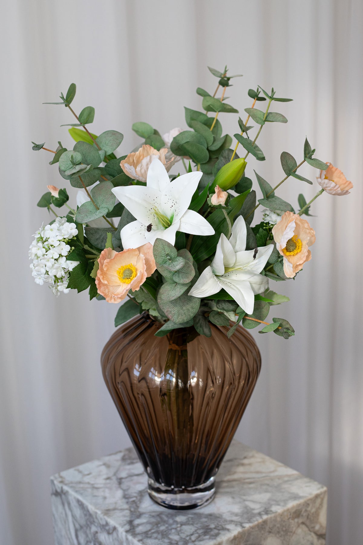Kunstig buket, der ser ægte ud, da detaljegraden er meget naturtro. Buketten består af eukalyptus, valmuer og liljer, der giver en smuk og luftig buket.