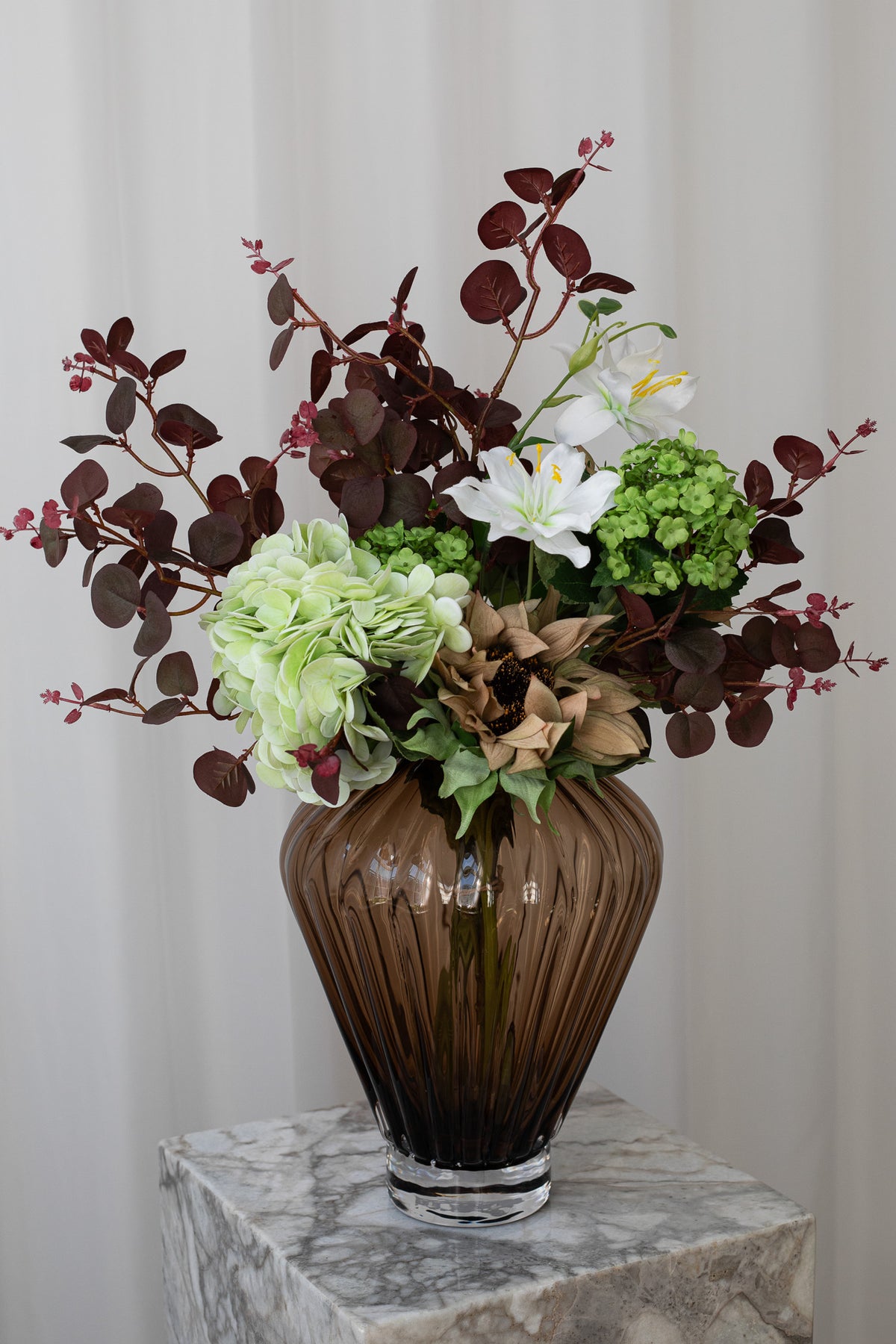 Nærbillede af en kunstig, naturtro buket med hortensia, solsikke og andre luftige stilke fra Specktrum.
