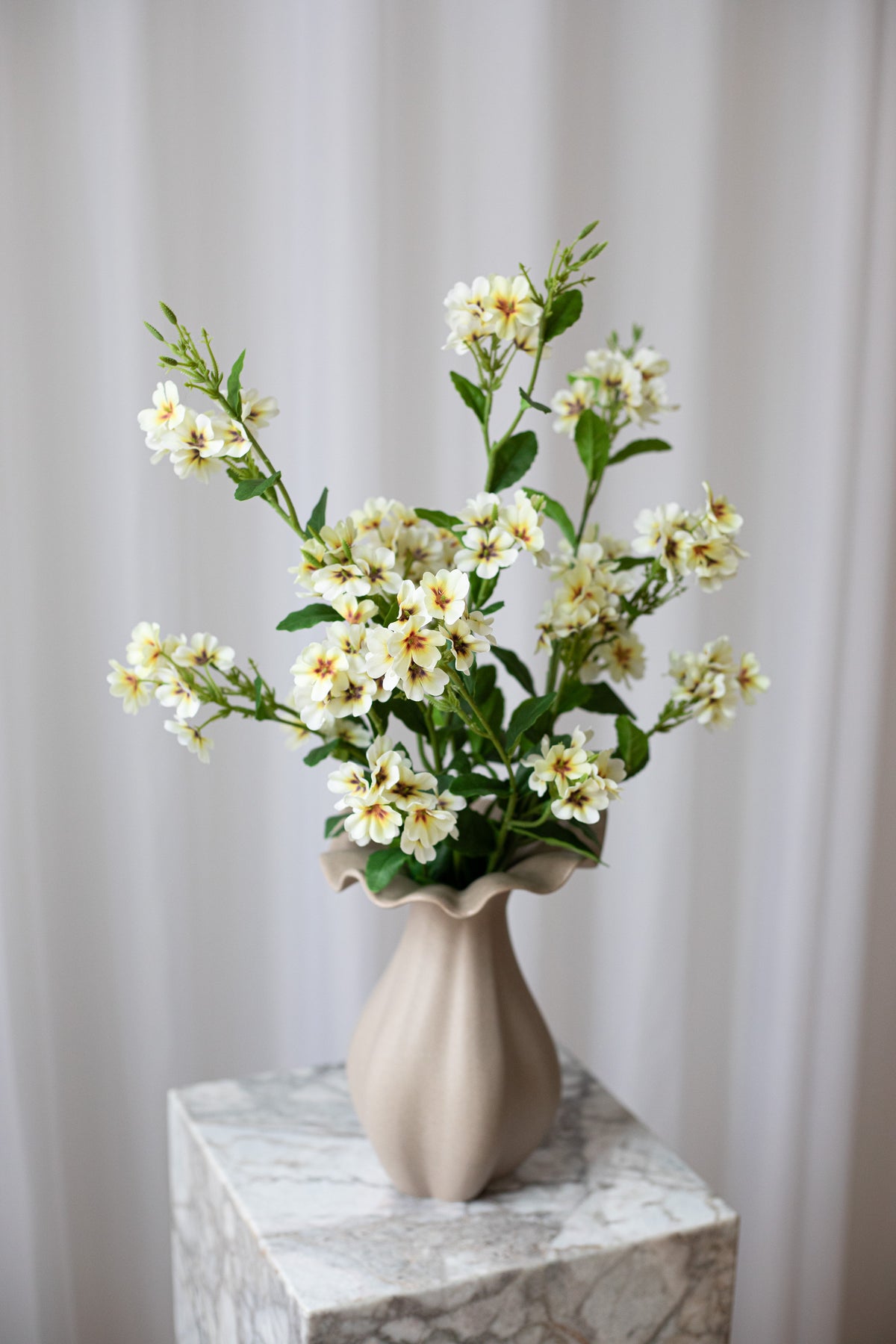 Nærbillede af en lysegul buket af naturtro, kunstige blomster fra Specktrum.