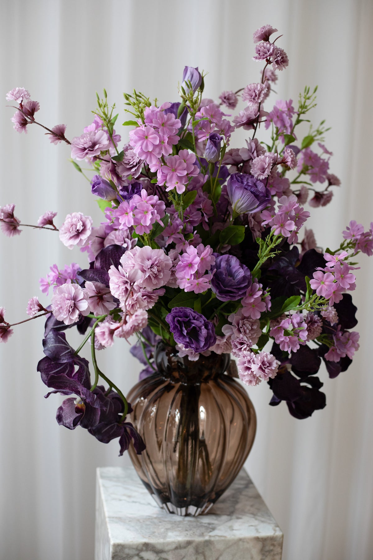 Nærbillede af en stor buket af lilla blomster. Den kunstige buket er luftig og ser naturtro.