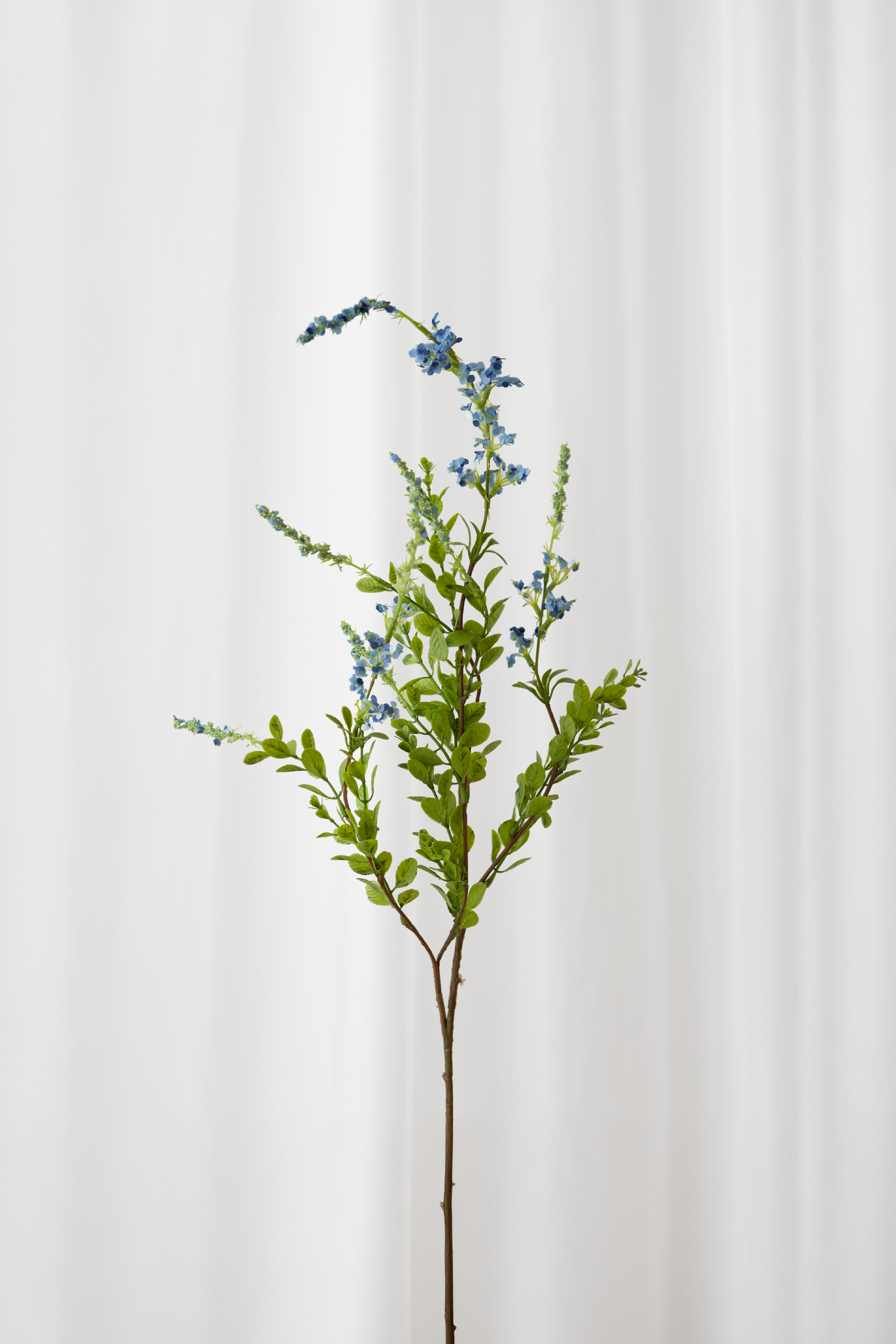 Naturtro kunstig sage gren med blå blomster og grønne blade med høj detaljegrad.